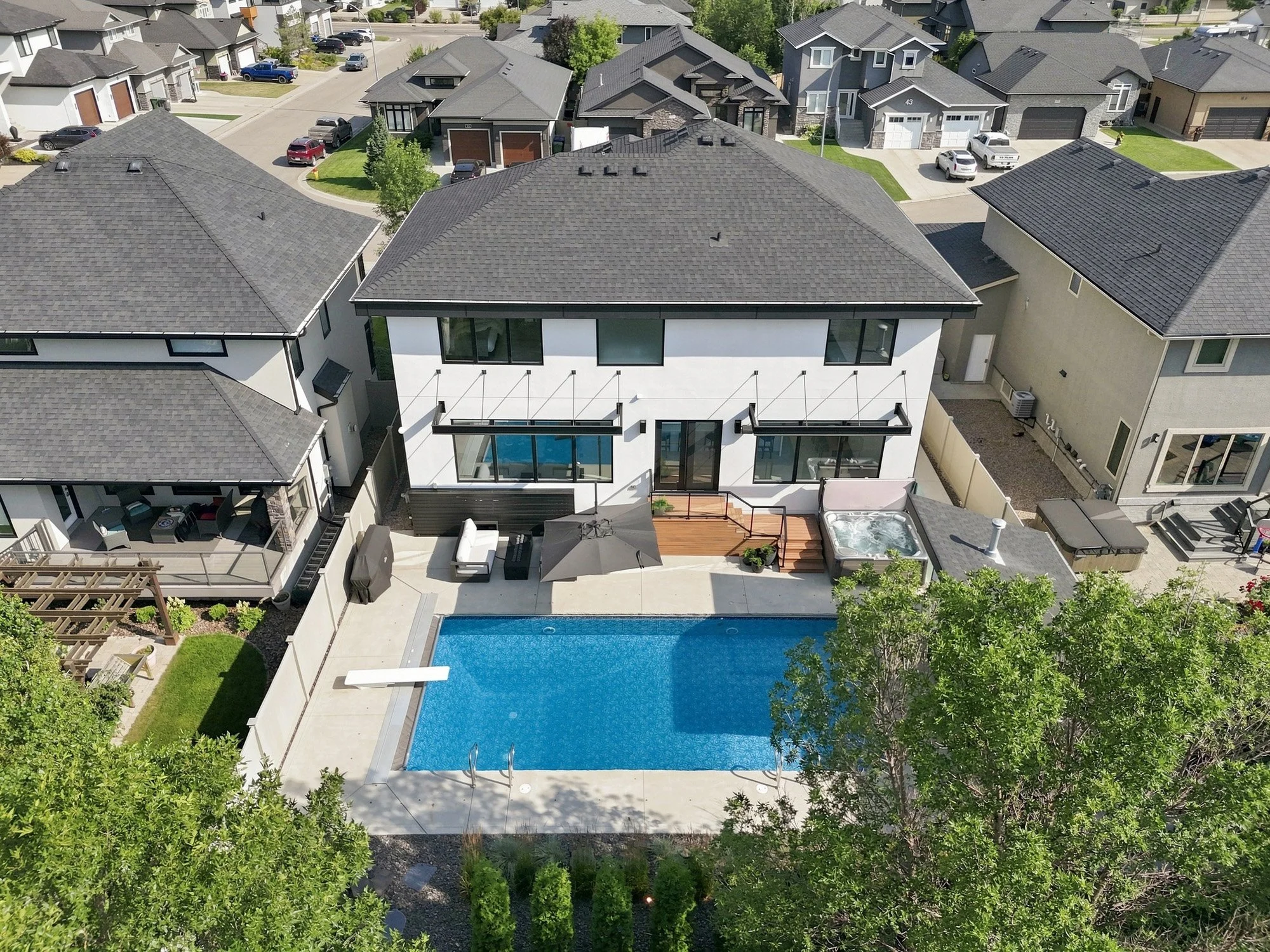 Aerial view of a modern two-storey Saskatoon home with a dark grey roof.