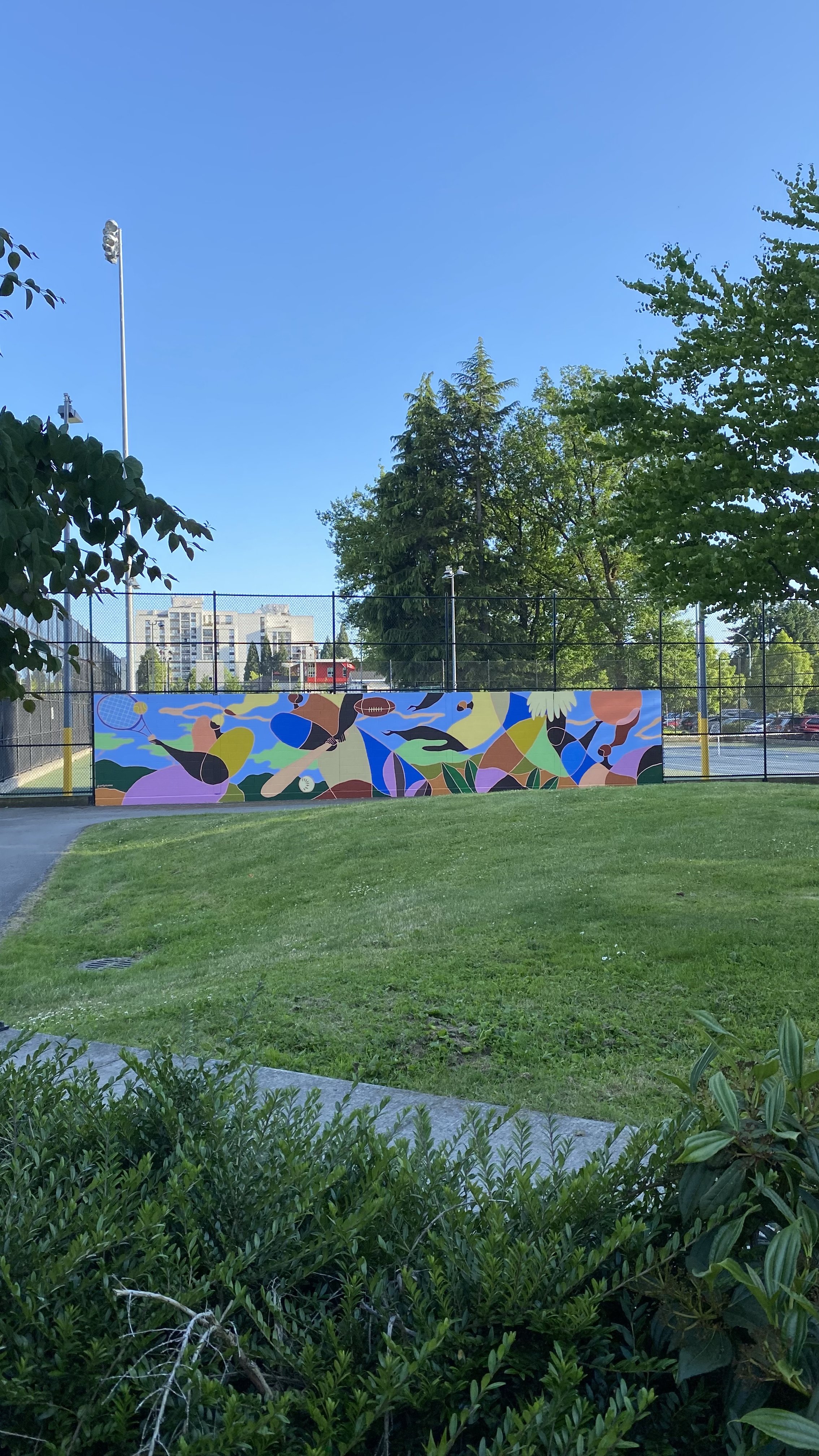 Arty Guava mural at Minoru Park Tennis Court in Richmond, featuring vibrant colours and joyful figures inspired by movement, sport, and community in a public outdoor space.
