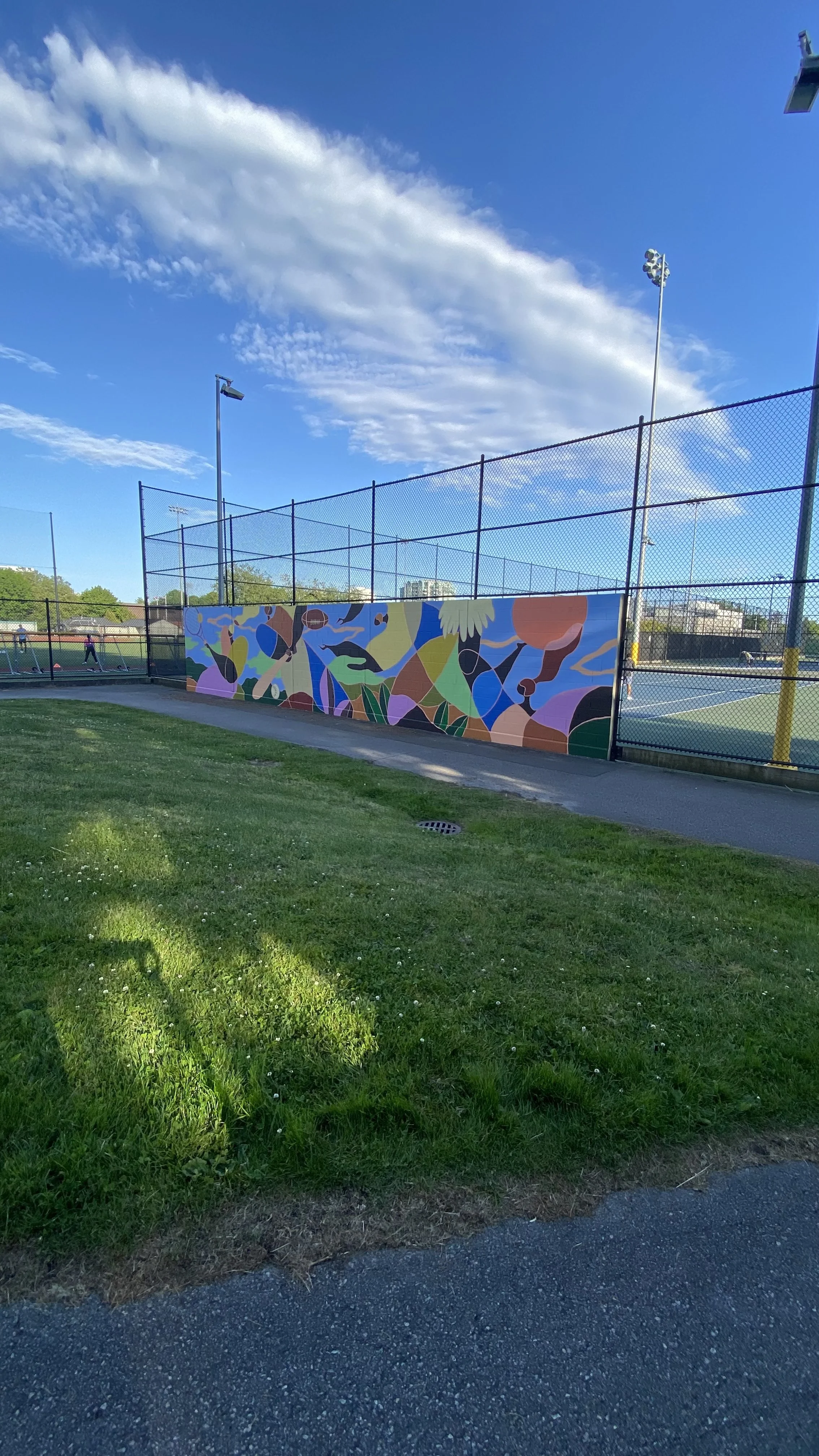 Arty Guava mural at Minoru Park Tennis Court in Richmond, featuring vibrant colours and joyful figures inspired by movement, sport, and community in a public outdoor space.