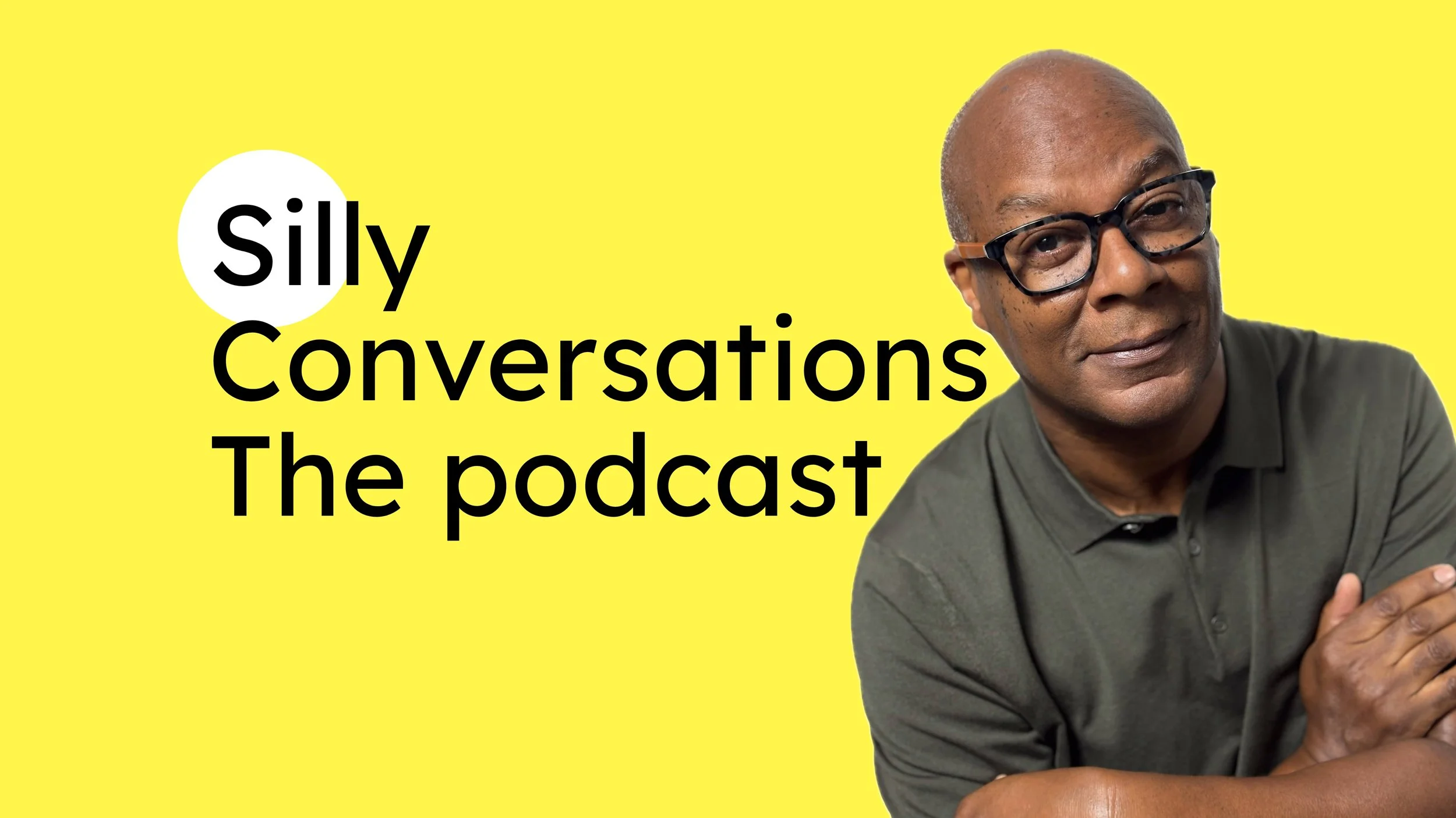 A man with glasses and a gray shirt smiling, with arms crossed, against a yellow background. Text reads 'silly Conversations The podcast'.