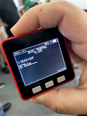 A person's hand holding a red and black electronic device showing a train schedule on its screen.