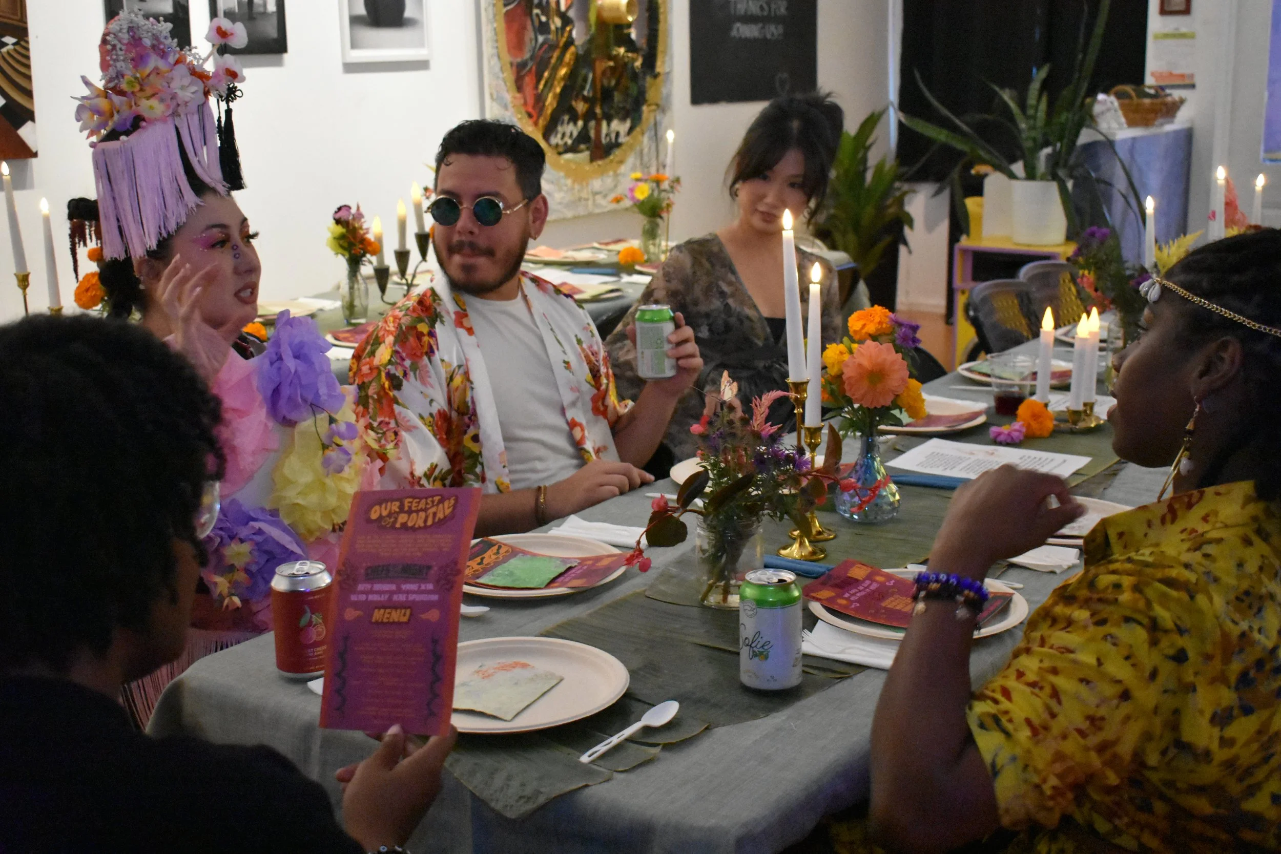 People sitting around a dining table decorated with flowers and candles, celebrating at a festive gathering.