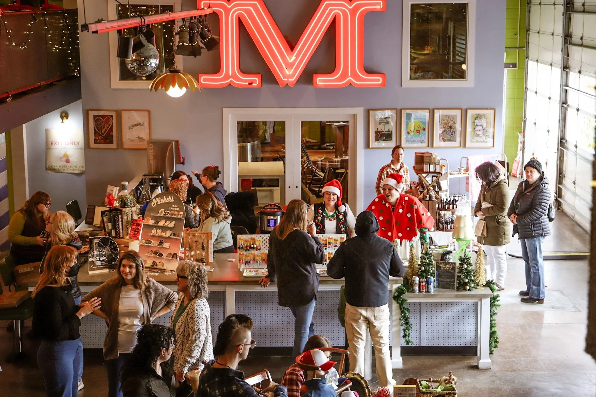   Festive market  at Flying M Coffeegarage with shoppers exploring local artisan vendors, including Fire and Fringe’s sterling silver and turquoise jewelry. The lively holiday atmosphere mirrors the friendly values of  Flying M.  