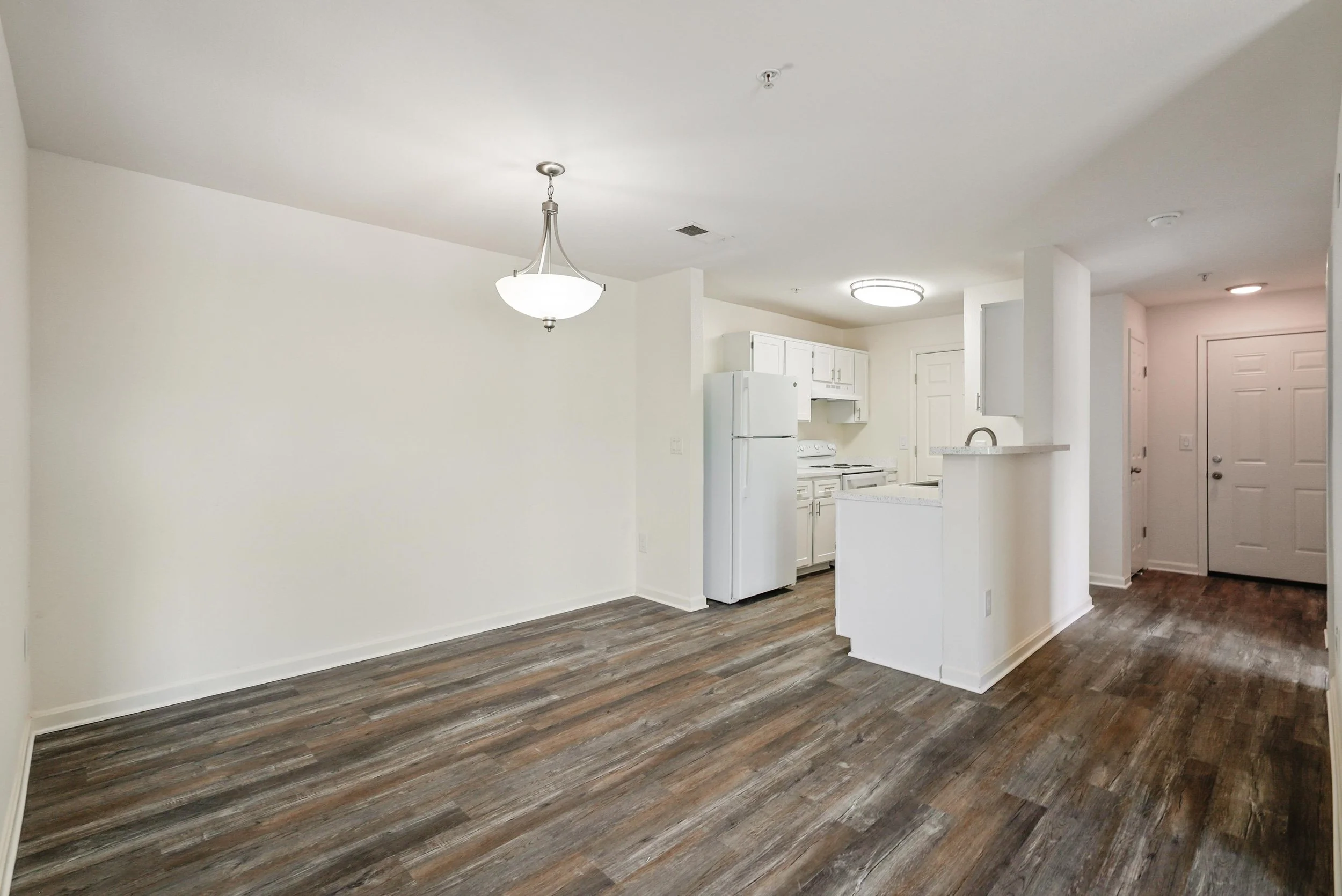  Open-concept dining and kitchen space, featuring recently updated flooring in select  standard market apartment homes. 