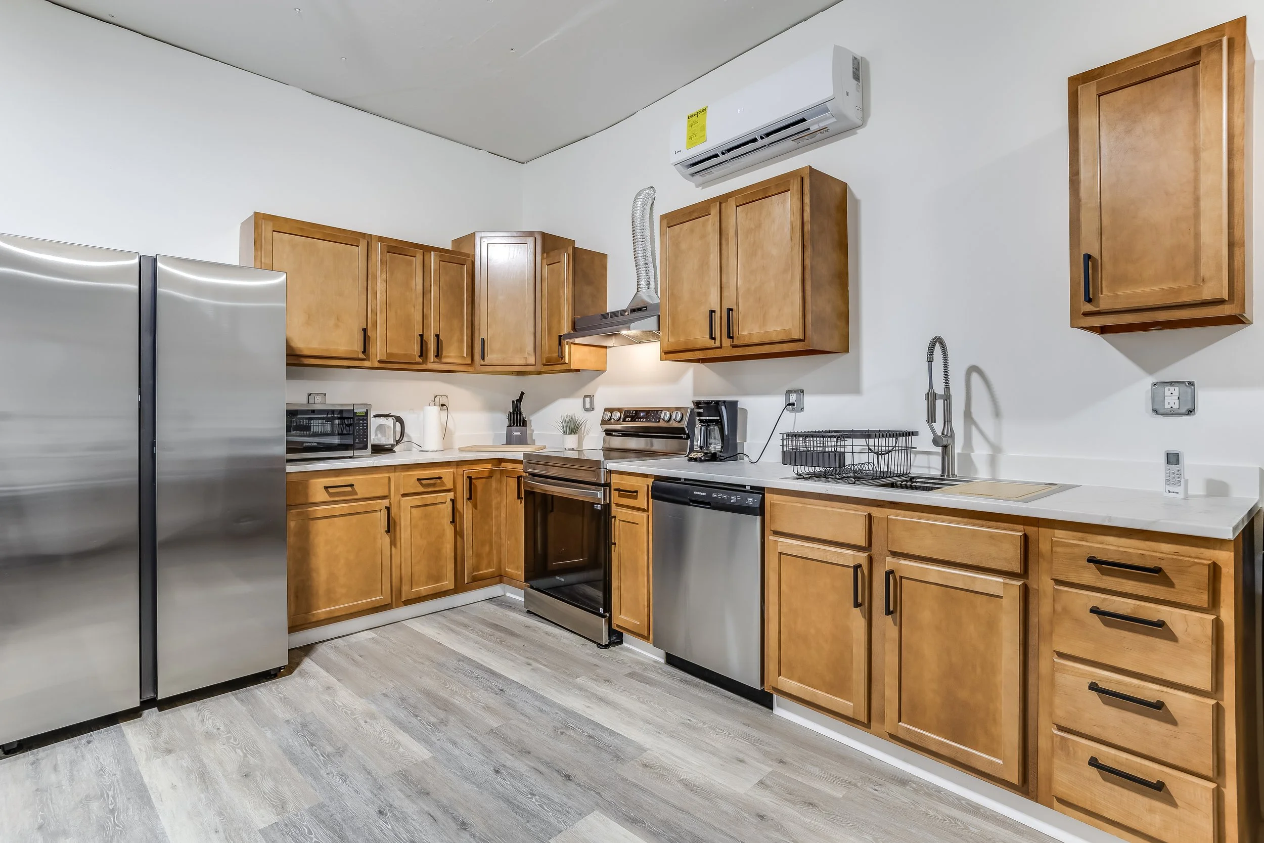 Renovated kitchen inside the Atlas-F missile silo with a farmhouse sink, stainless appliances, and original blast-hardened steel support beams in Carlton, KS.