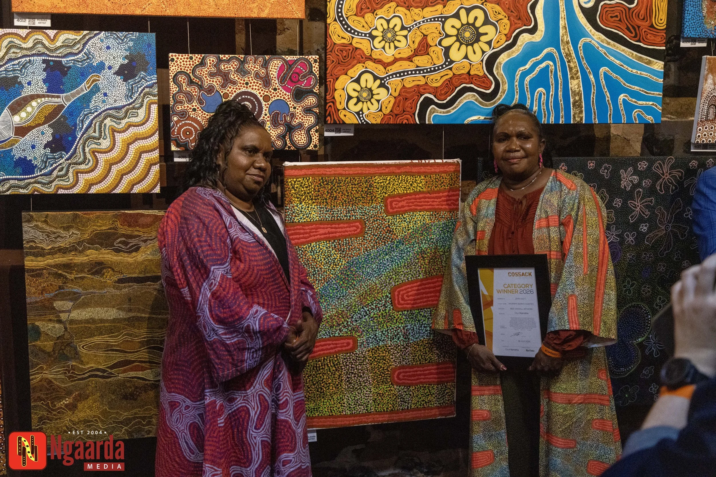 [HERO PHOTO: Jenny Butt with her winning artwork, Nyurnma (Burnt Country), at the Cossack Art Awards. Suggested caption: Bidyadanga artist Jenny Butt won Best Overall Artwork at the 2026 Cossack Art Awards.]