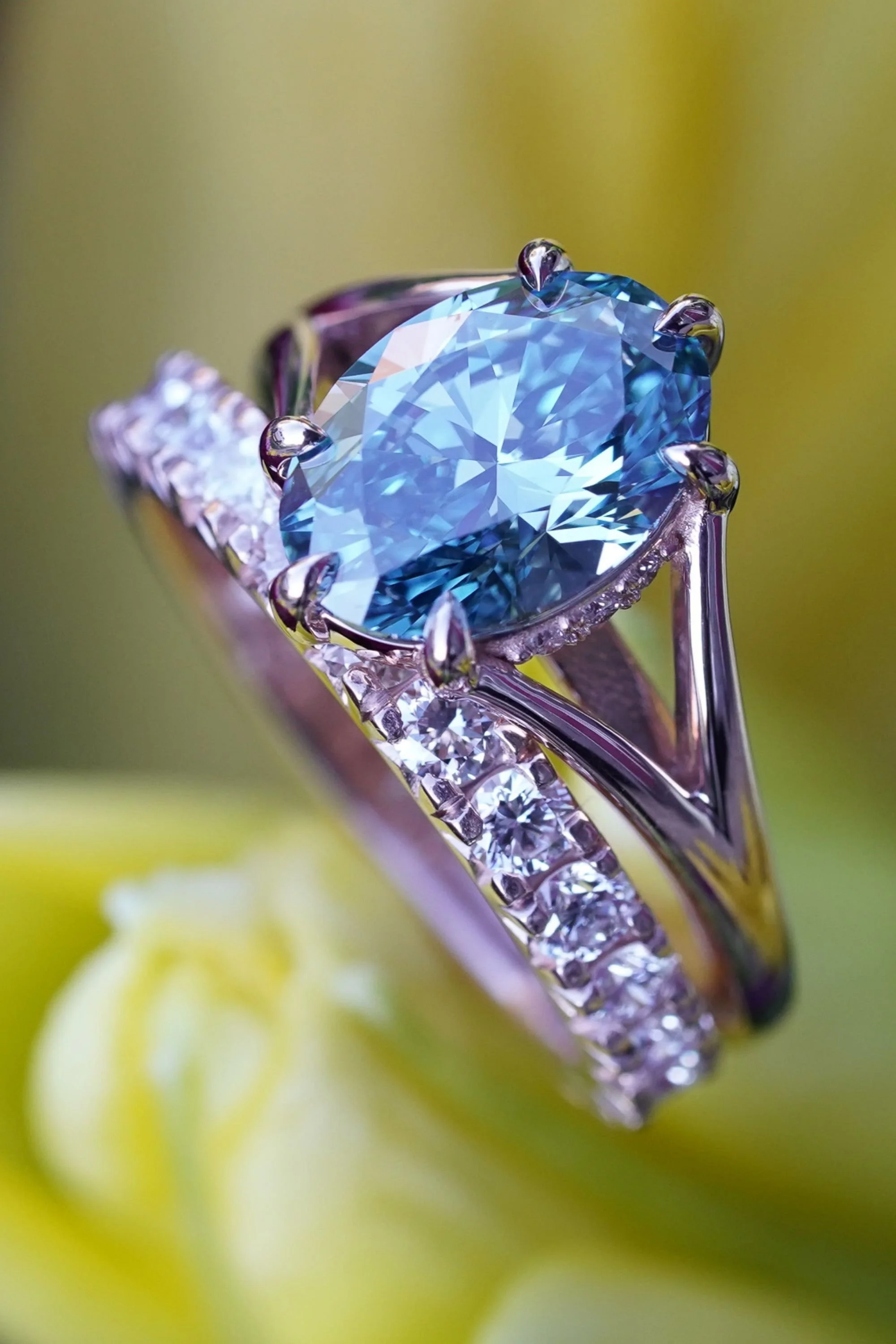 Close up shot of a blue diamond engagement ring with a hidden halo