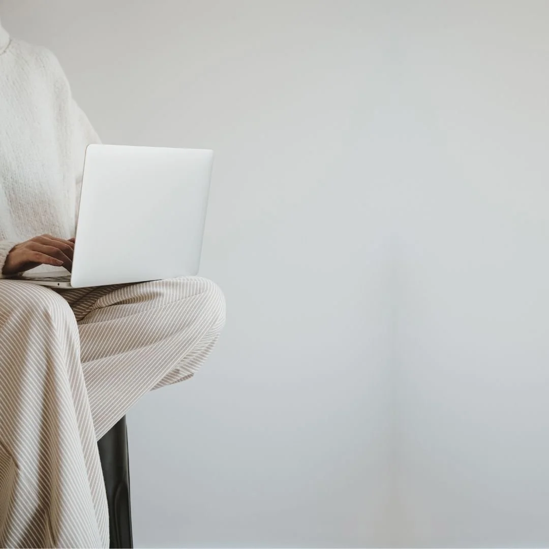 woman doing SEO sitting a stool with a computer