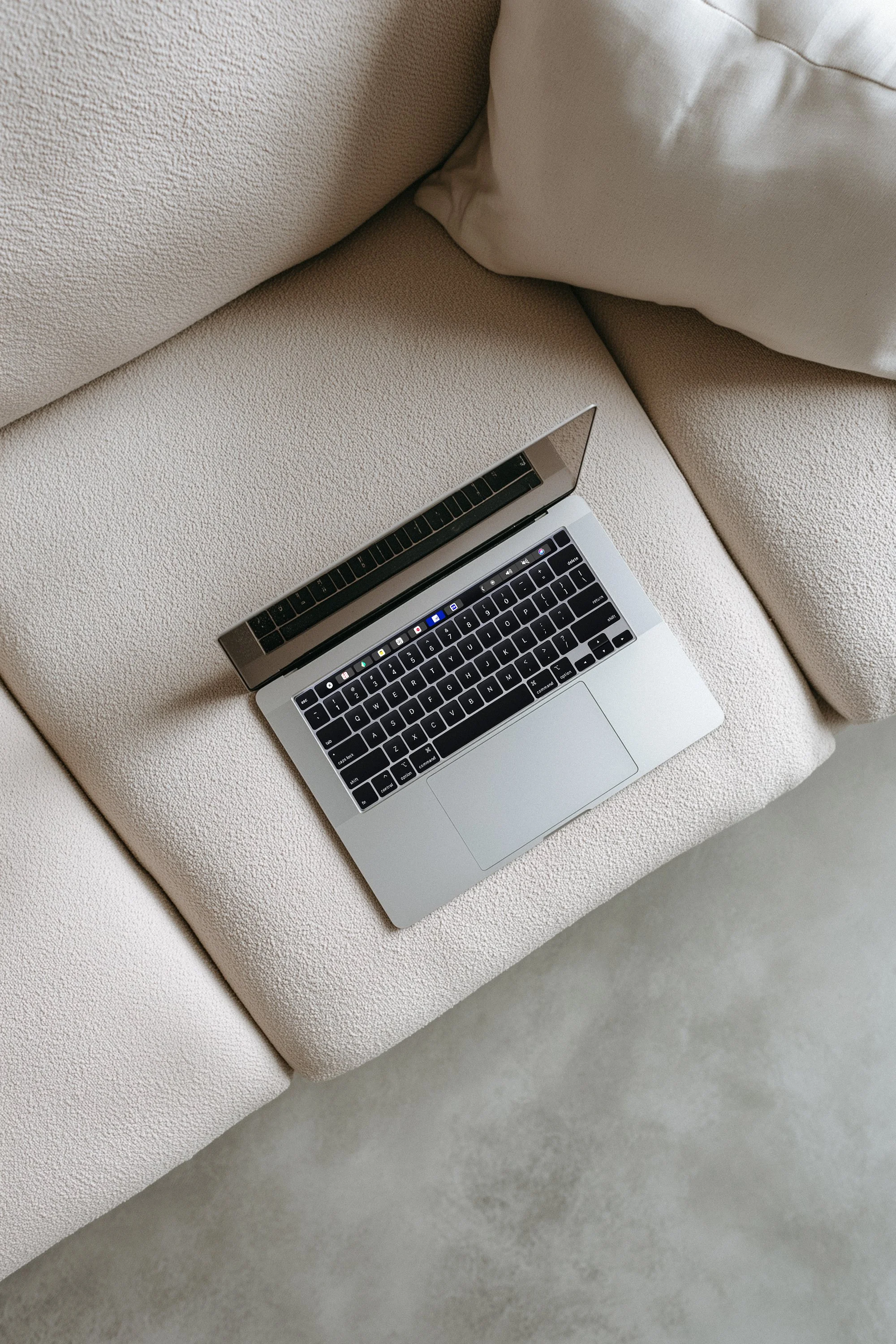a laptop on a couch in neutral colors