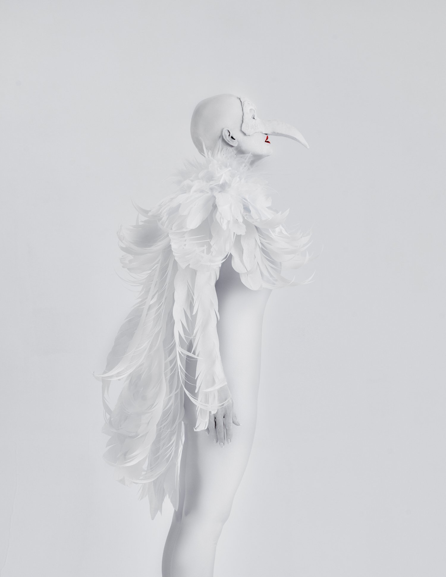 Editorial Photo of Harpy looking up. Her wings hanging down her back. She has red lips and looks sad