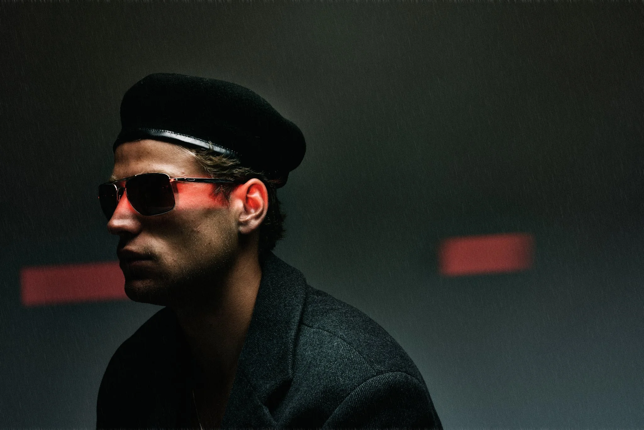 Man wearing sunglasses and beret in dark setting