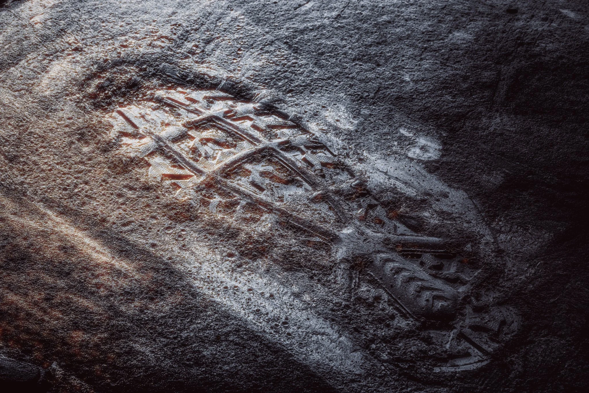 Close-up of a moon dust soil with sneaker prints and textured surface.