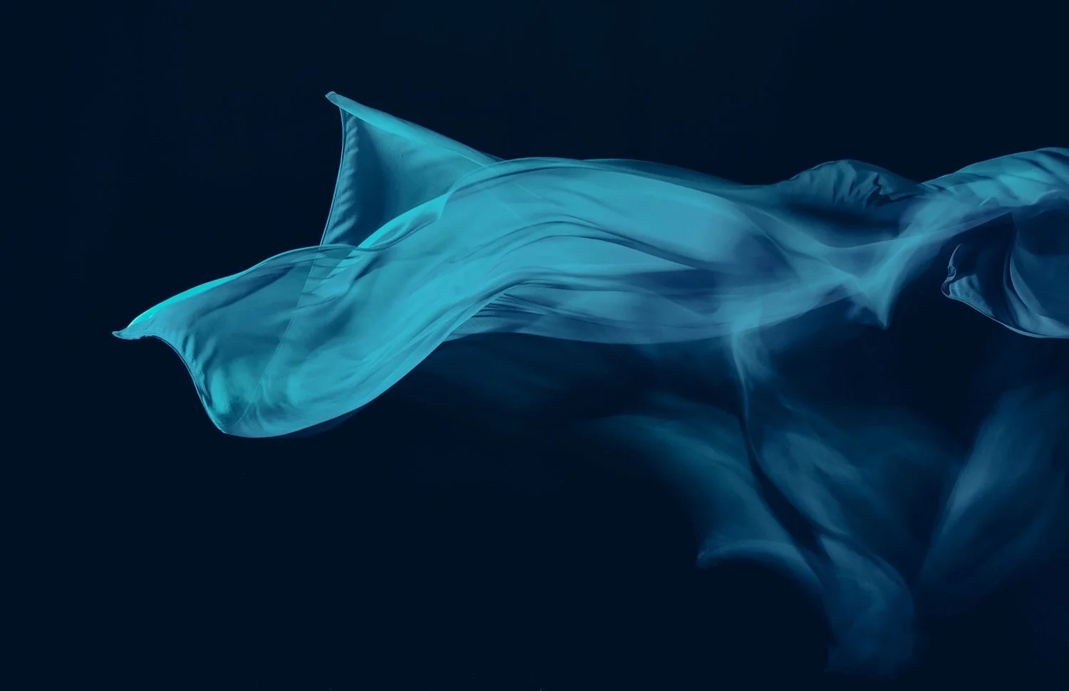 Ethereal blue sheer fabric flowing against dark background