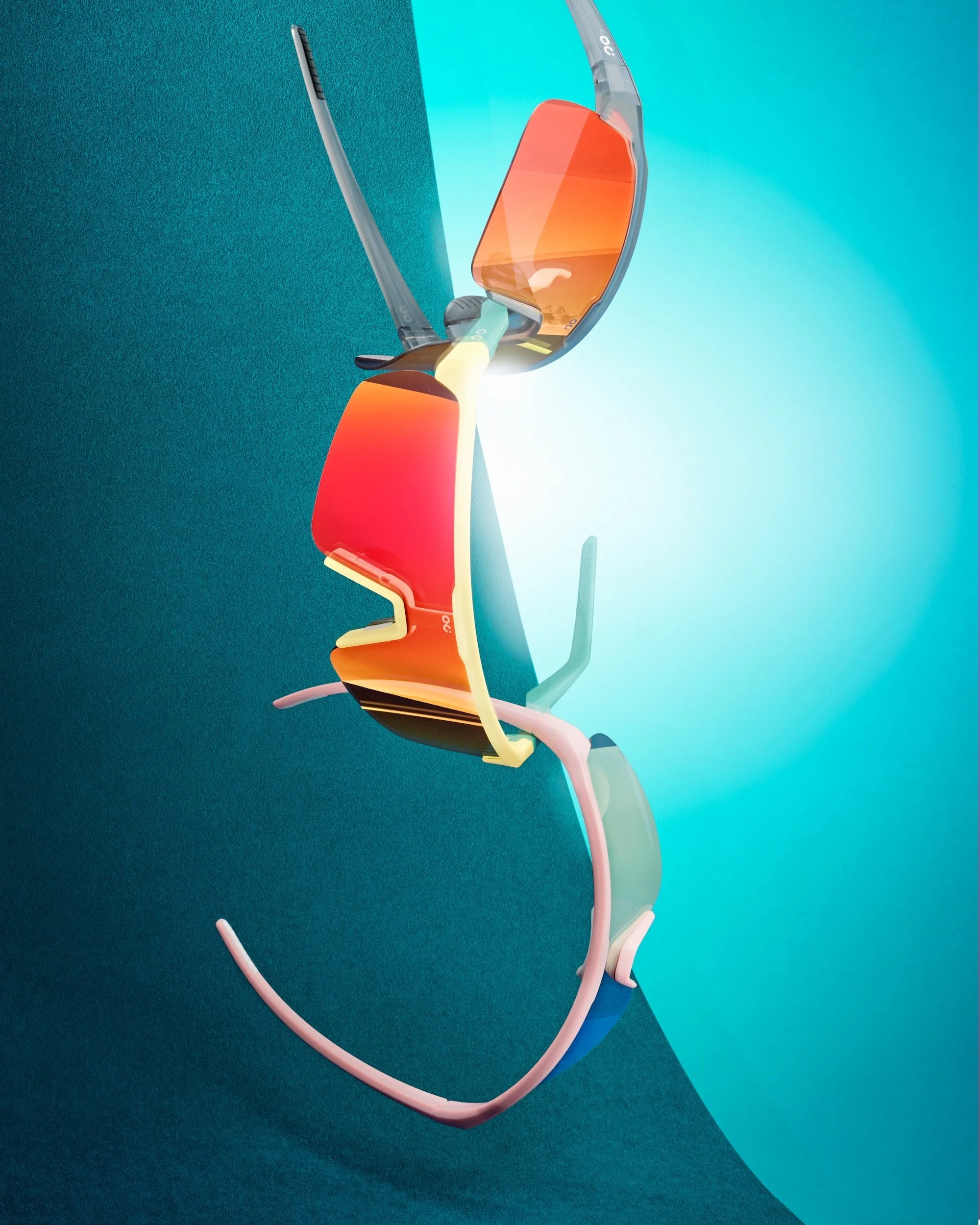 A sports sunglasses with a sleek design and tinted orange lenses, positioned against a blue-green background.
