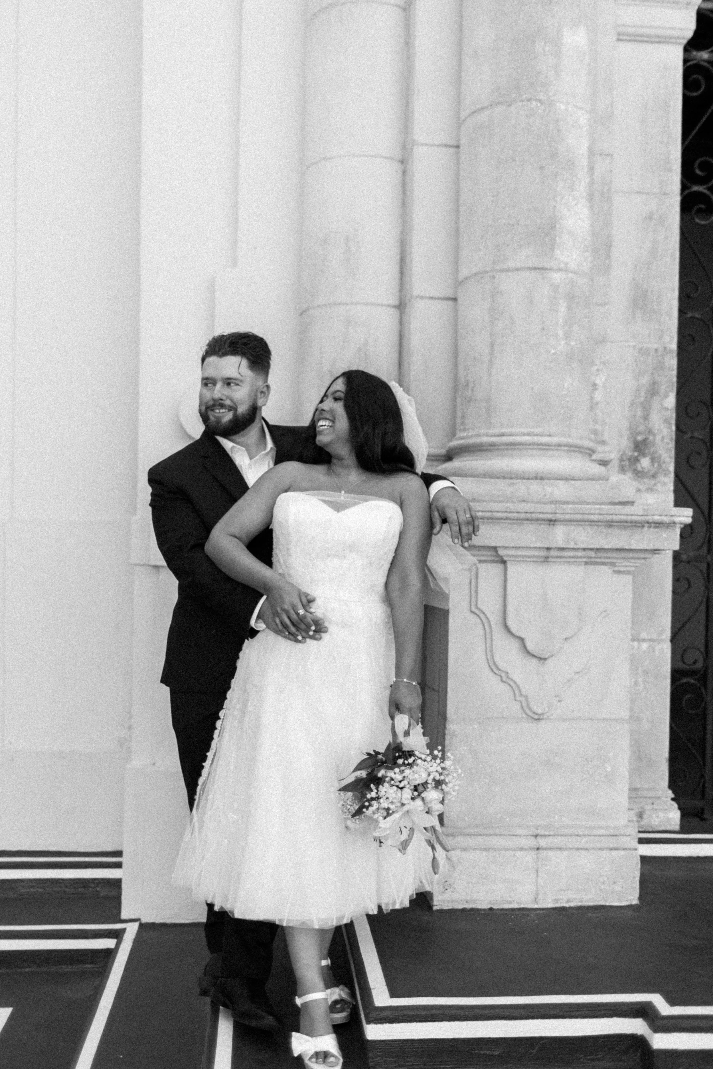 A bride and groom smiling and embracing during their wedding ceremony in a church.