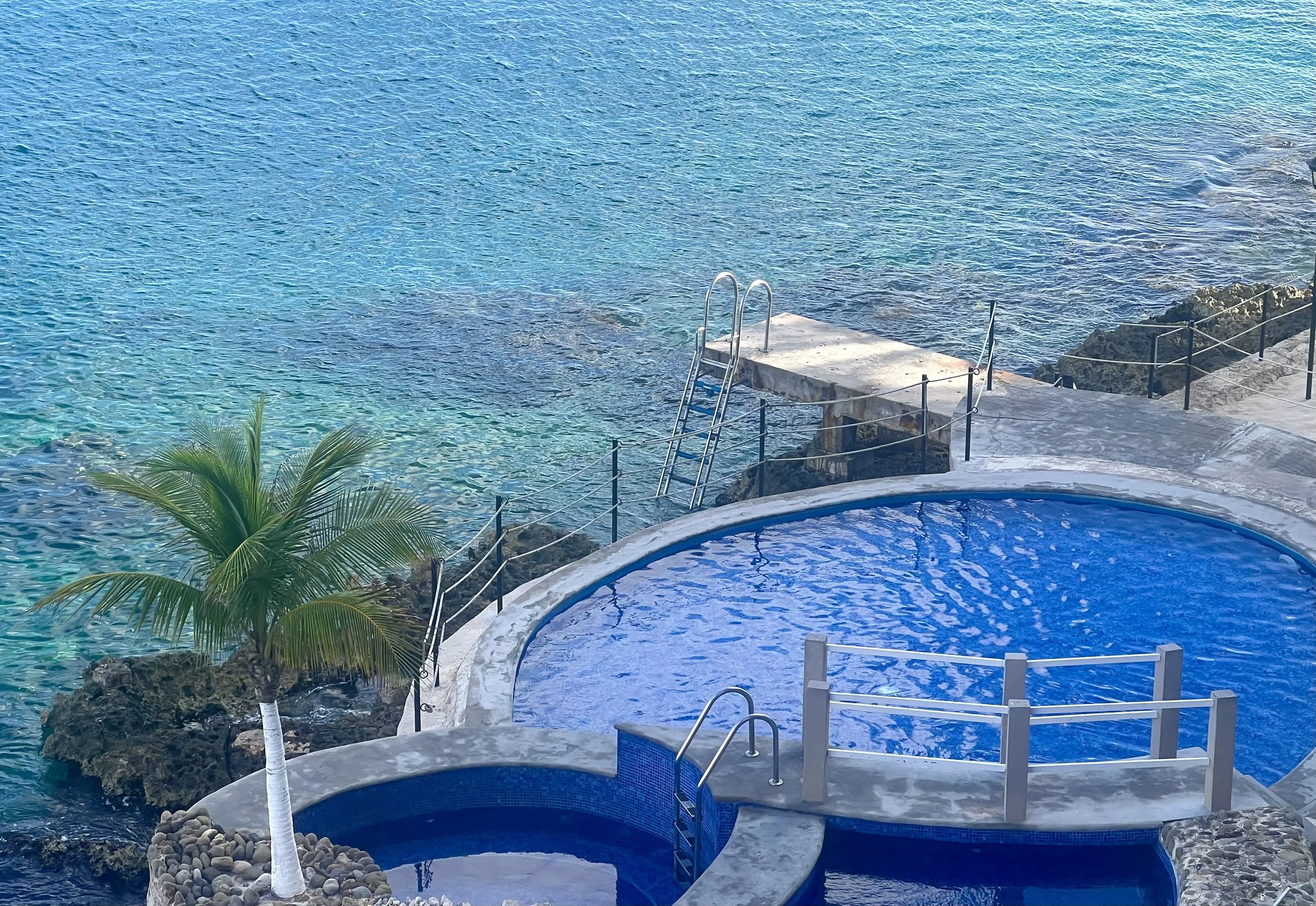 El Cantil oceanfront condominiums in Cozumel with waterfront swimming pool and private pier extending into the Caribbean Sea.