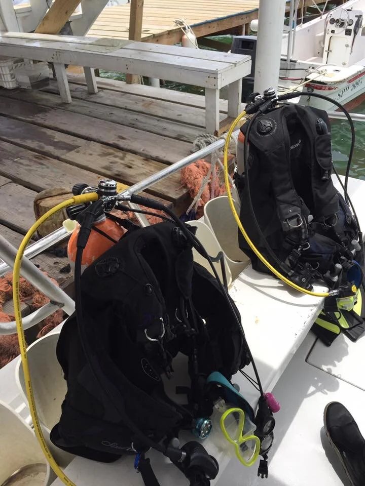 Dory and Jefe's scuba diving gear ready on the dock in Ambergris Caye, Belize