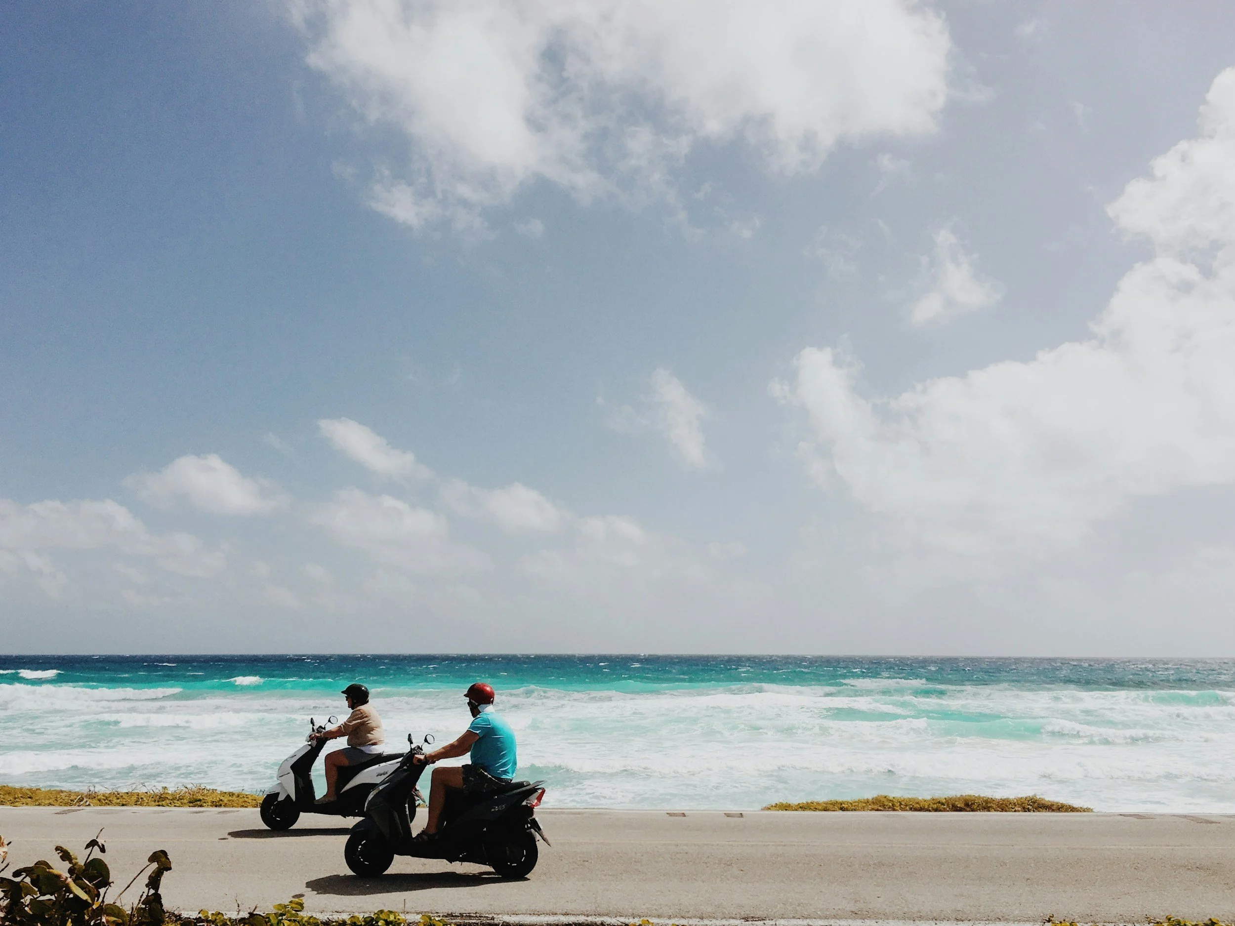 Traveler riding a scooter along Cozumel's scenic coastal road, a popular transportation option for exploring the island.