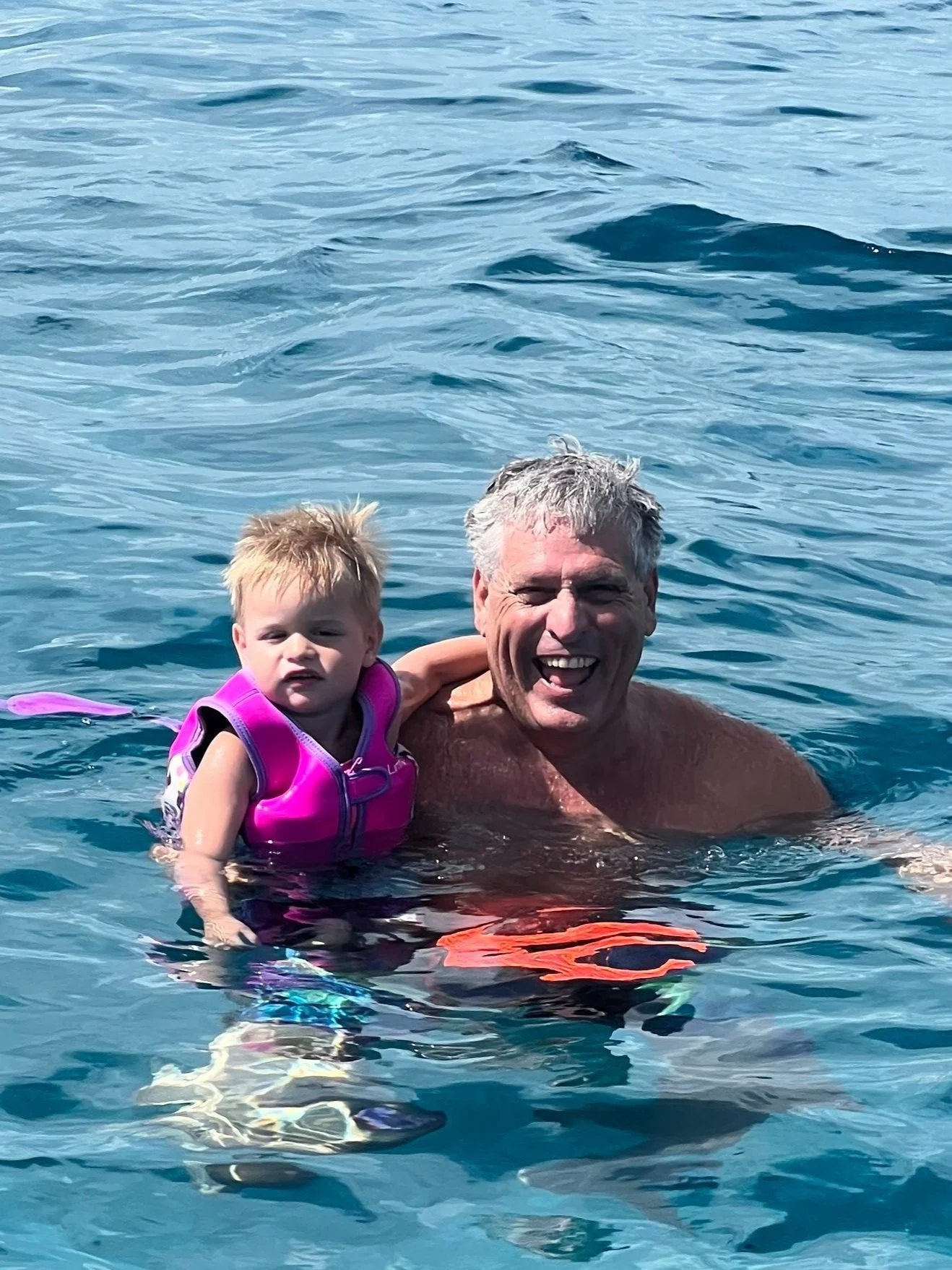 Jefé and toddler Levi floating in the Caribbean while the family snorkels in Cozumel