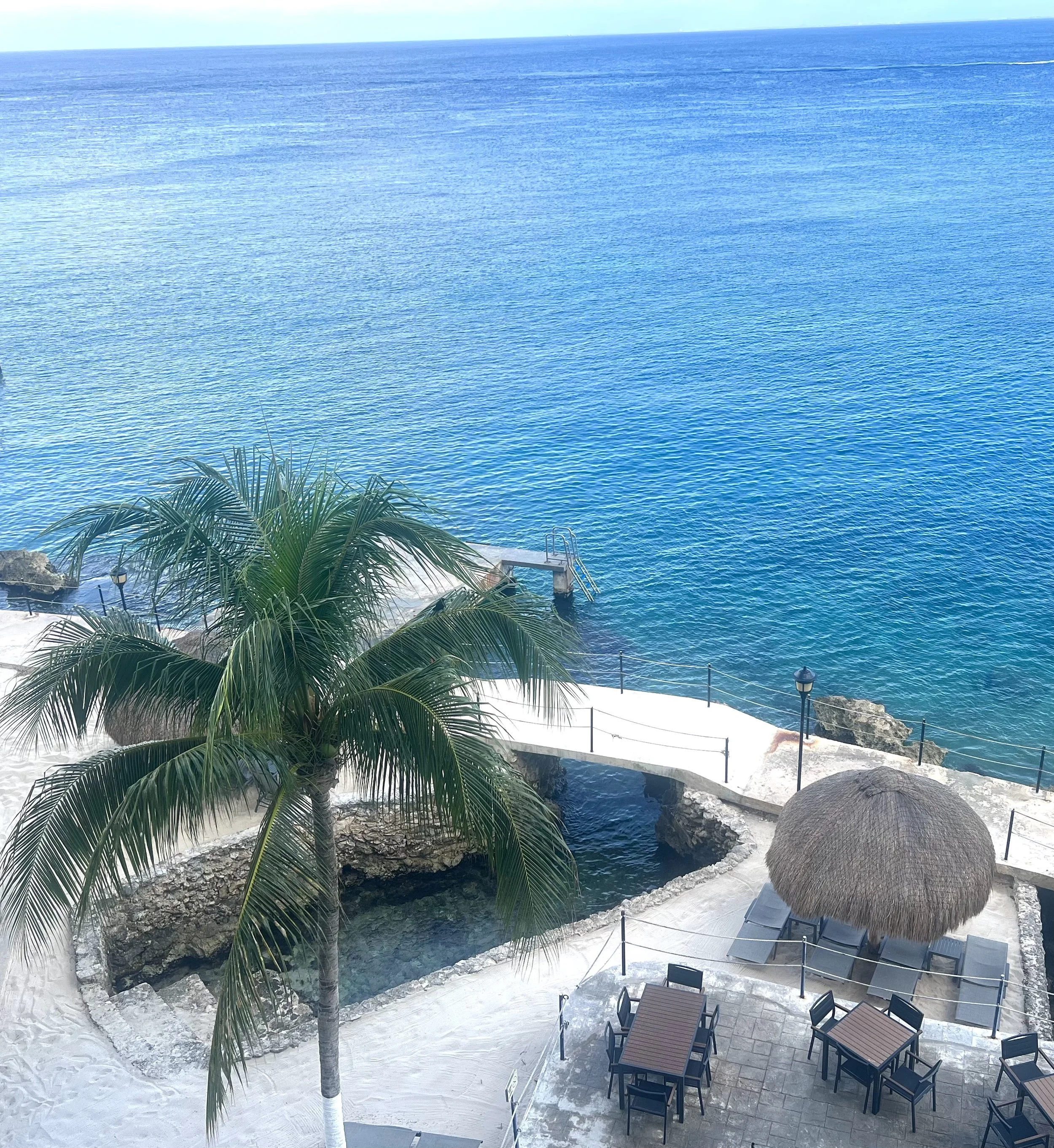 Private pier, beach and waterfront seating area at El Cantil oceanfront condominiums in Cozumel overlooking the Caribbean Sea.
