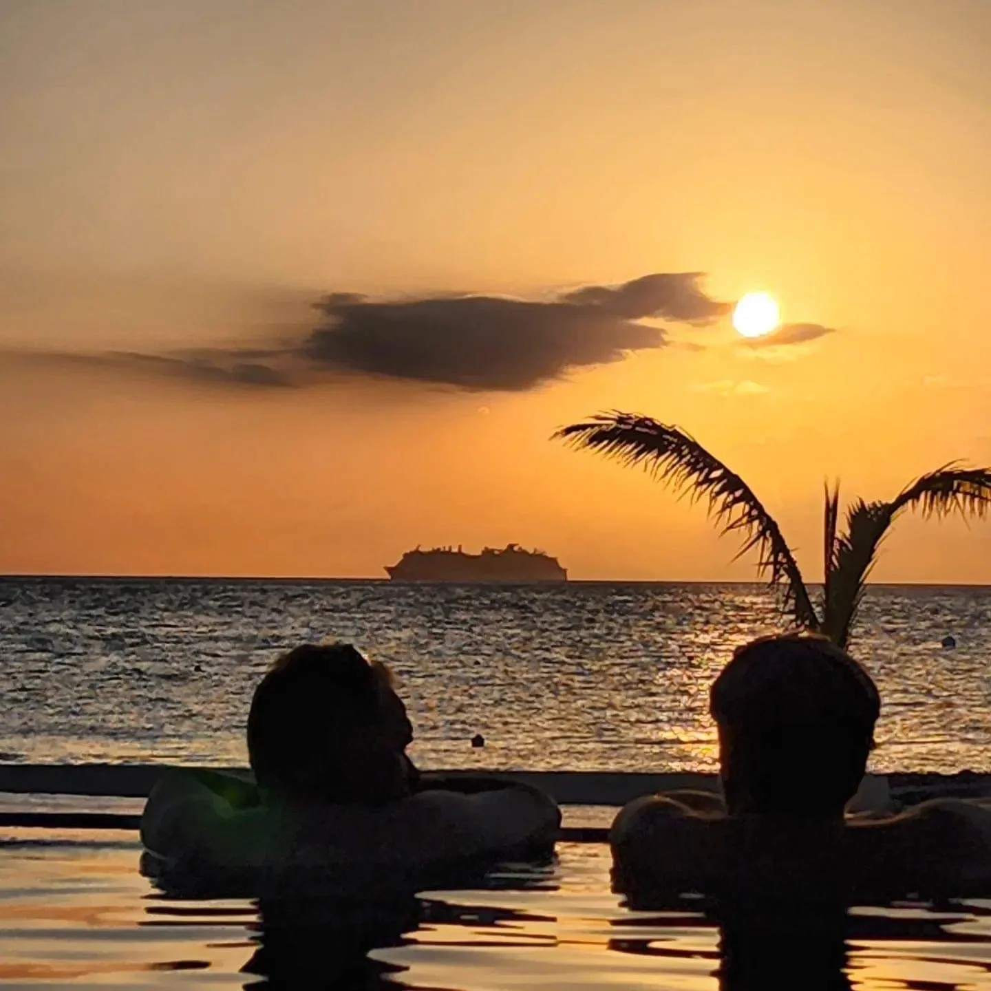 Guest enjoying the sunset with Jeff "Jefé" Coleman overlooking the infinity pool and Caribbean Sea at Costa del Sol in Cozumel.