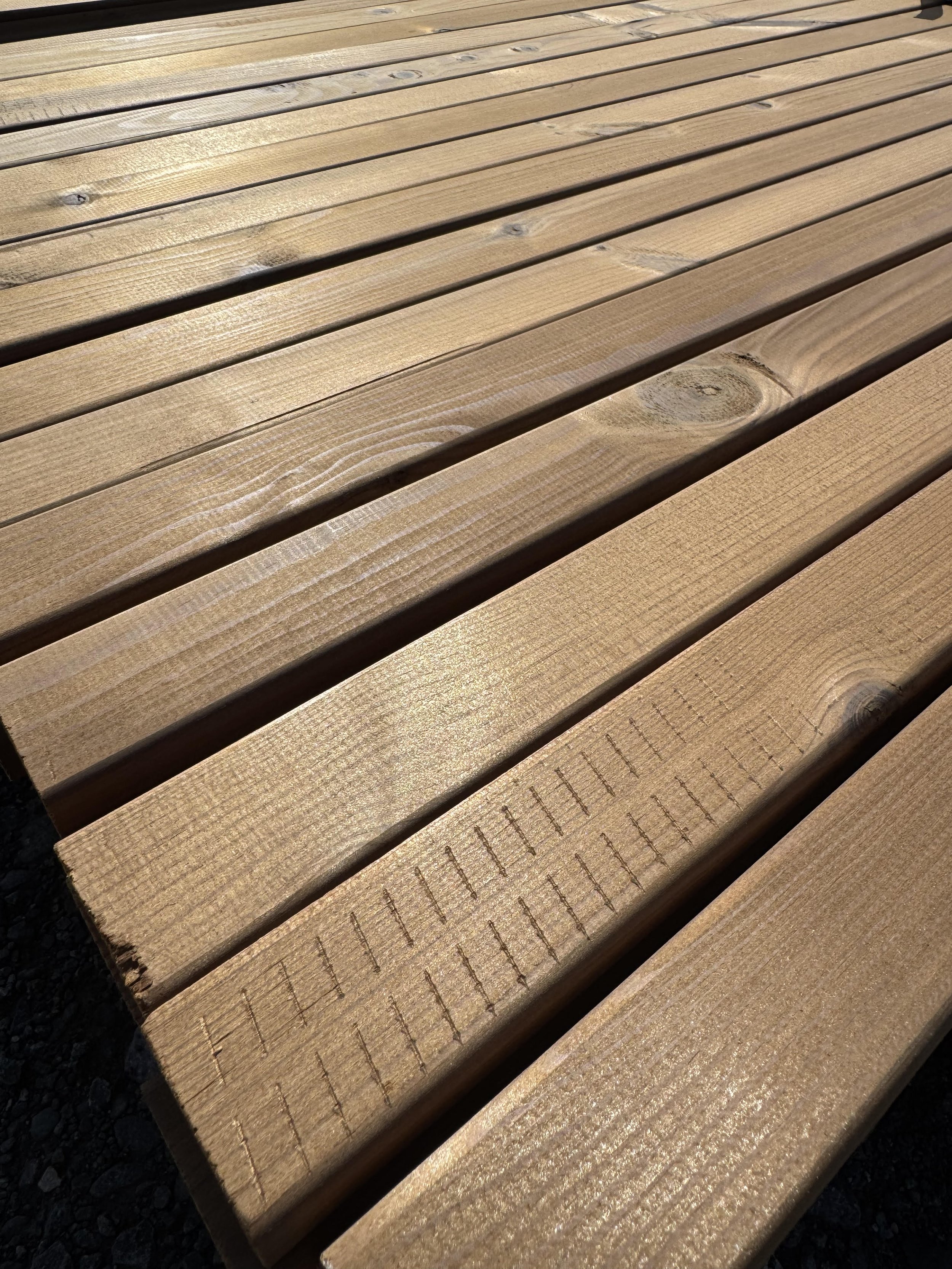 Thermo Timber Fencing battens in a bundle on a yard surface
