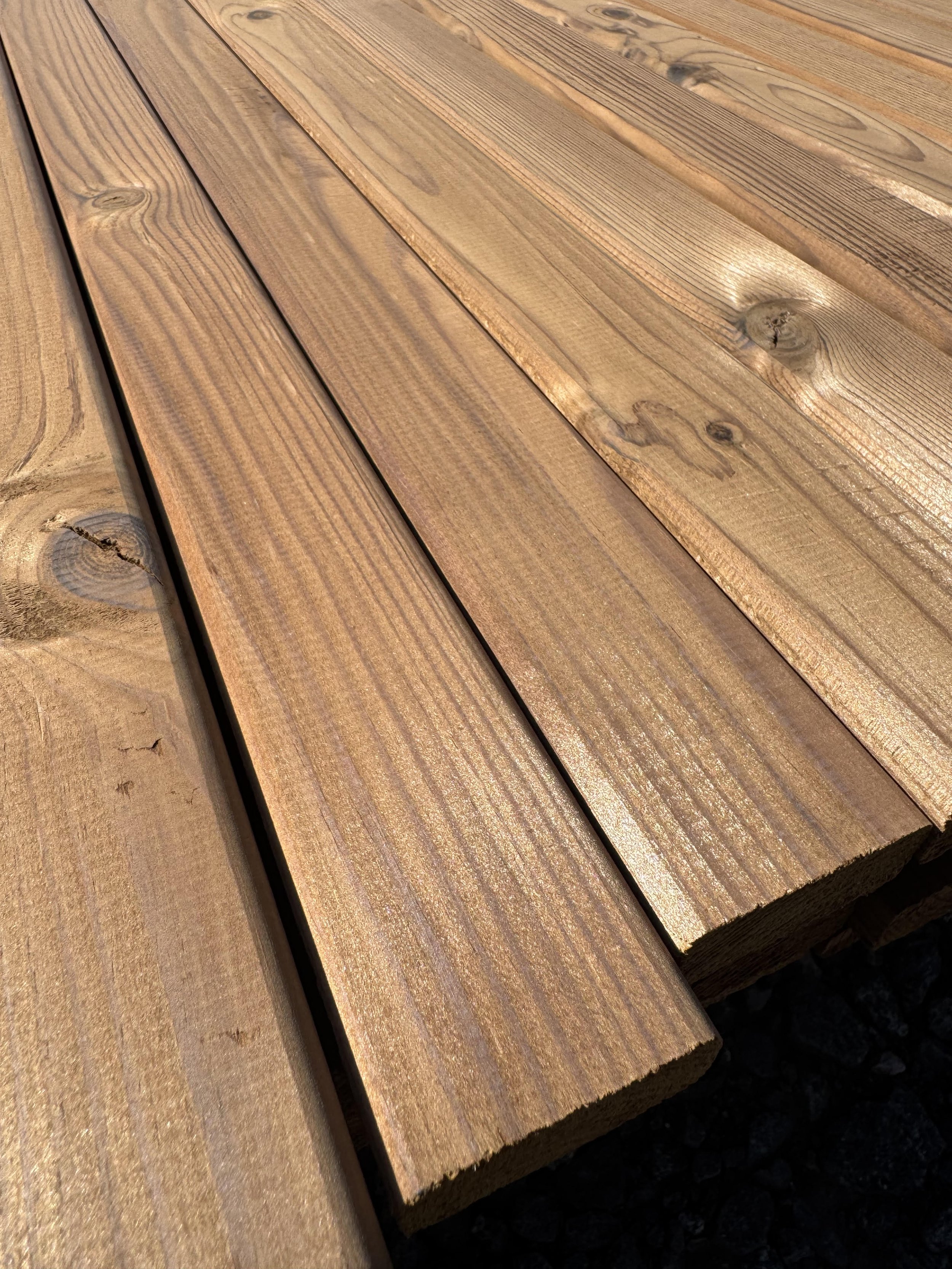 Thermo Timber Fencing battens in a bundle on a yard surface
