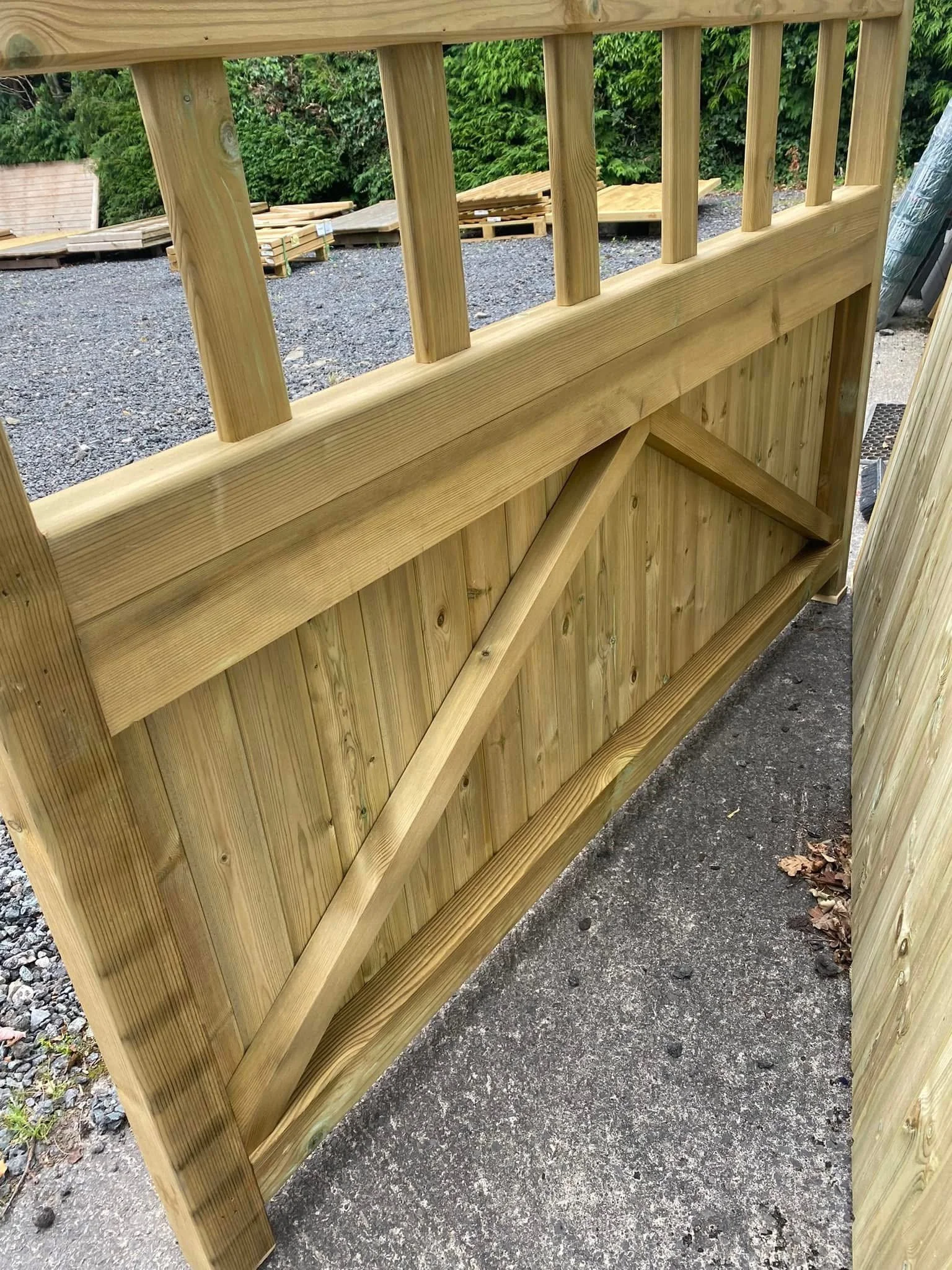 Wooden outdoor railing with vertical balusters and diagonal support brace