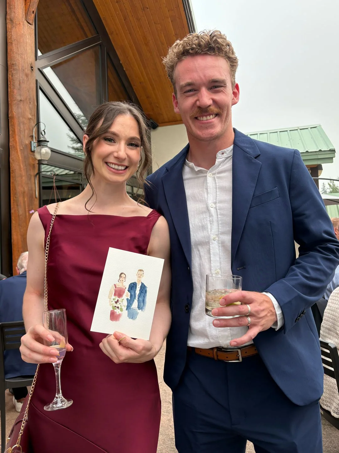 Guests at Fernie wedding holding watercolour and pencil portrait at Lizard Creek Lodge wedding.