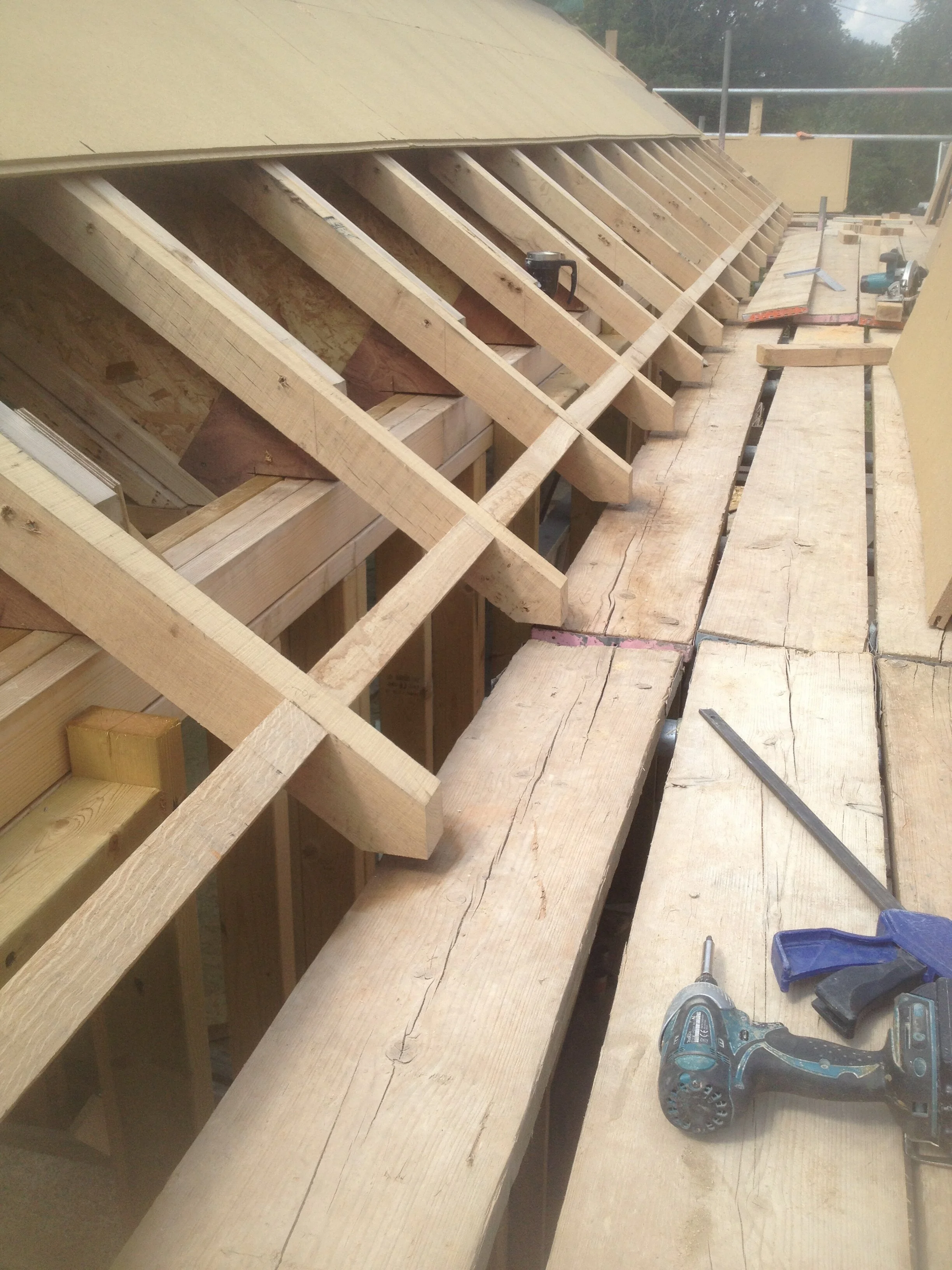 Oak sprockets or rafter ends are screwed onto the main rafters which end over the wall. You see the oak from underneath and its much neater than a boxed in soffit.