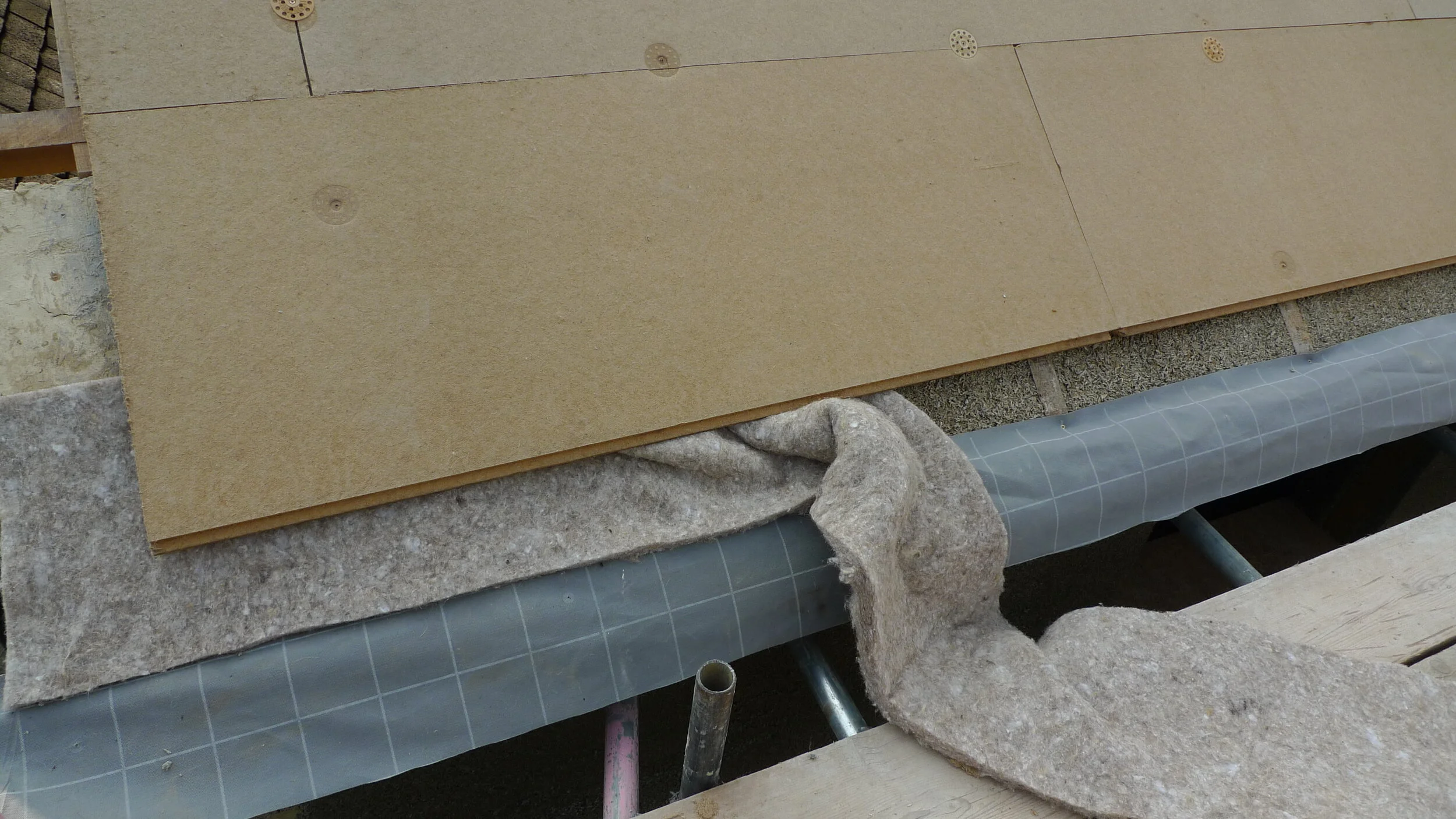 Where the woodfibre sarking boards are fixed over the hempcrete sheeps wool or hemp fibre insulation is sandwiched between the hempcrete and board to fill any gaps and act as an expansion gasket.
