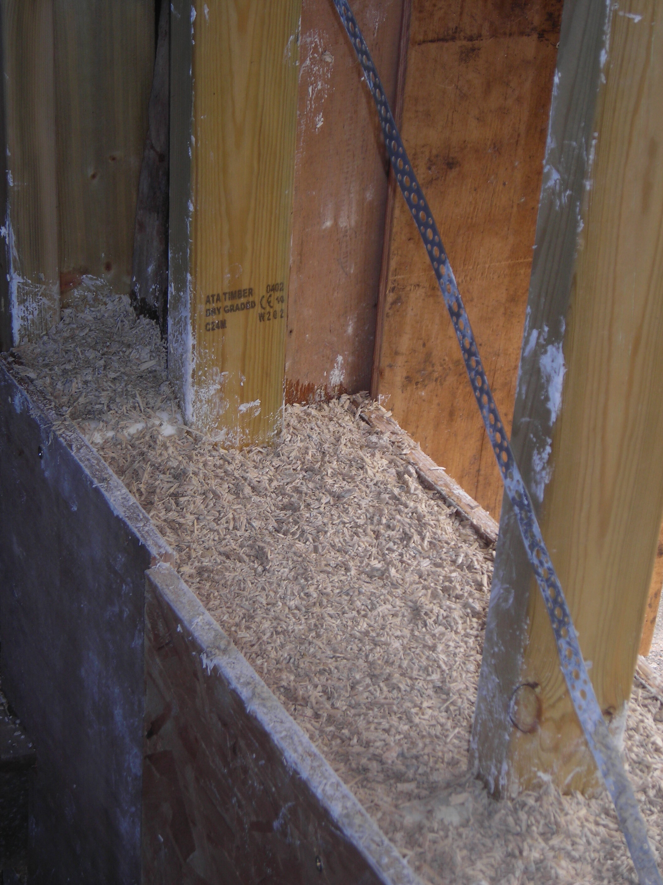 This extension is built on top of cob (earth and straw) walls. The cob is flexible, creating an extremely stiff box on top might cause differential movement as the cob adjusts to its new load. For this reason the owner/architect used stainless steel