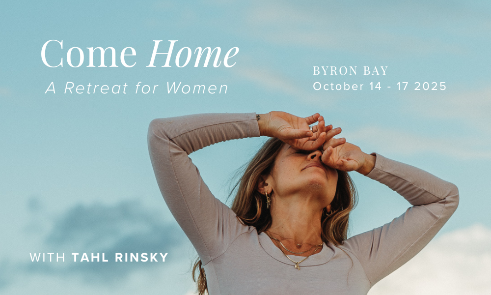 A woman outdoors shielding her eyes from the sun with her hand against a partly cloudy sky, promoting a women's retreat called 'Come Home' in Byron Bay from October 14 to 17, 2025.