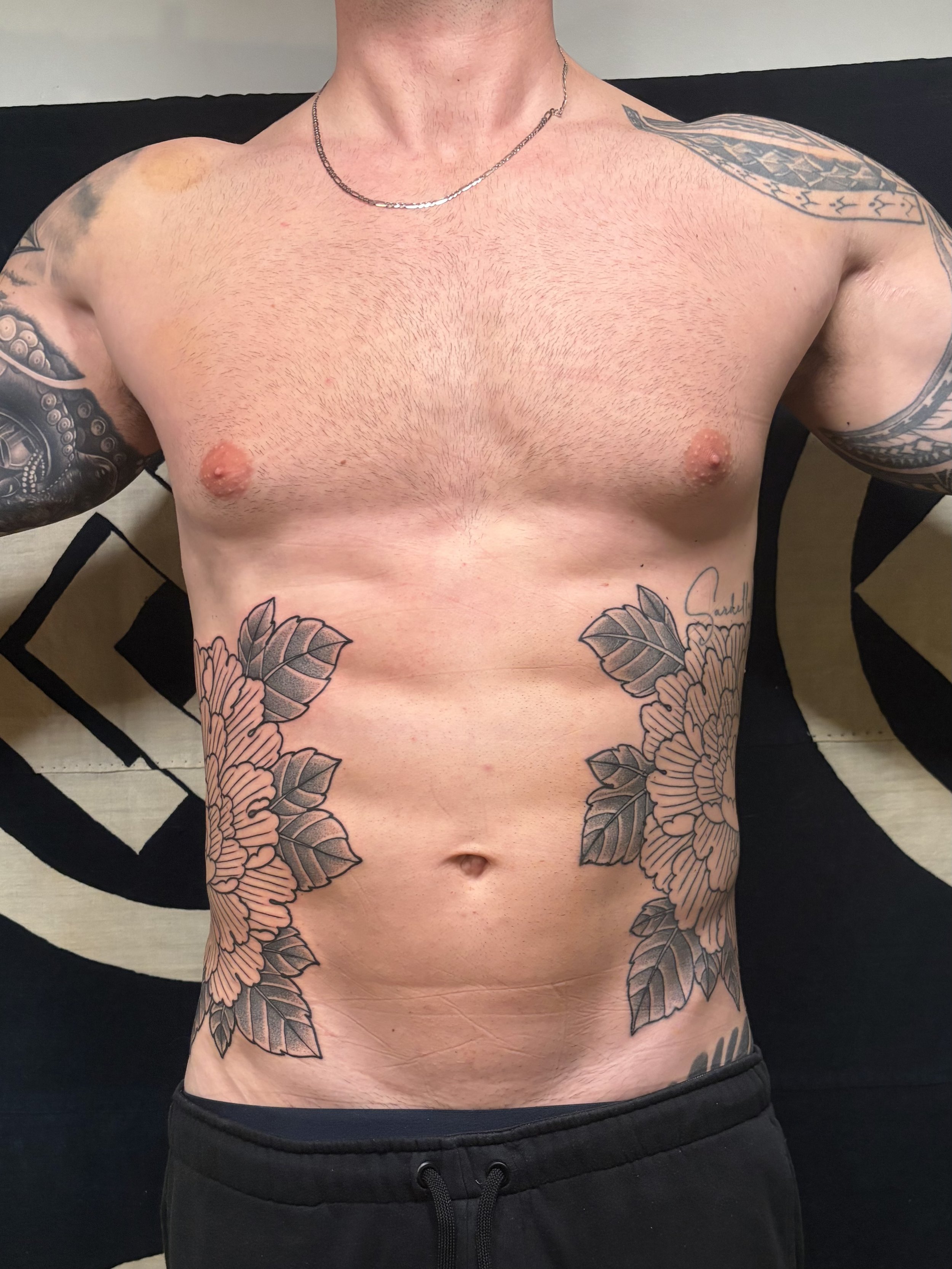 Men's Irezumi peony symmetrical side tattoos in bold blackwork style