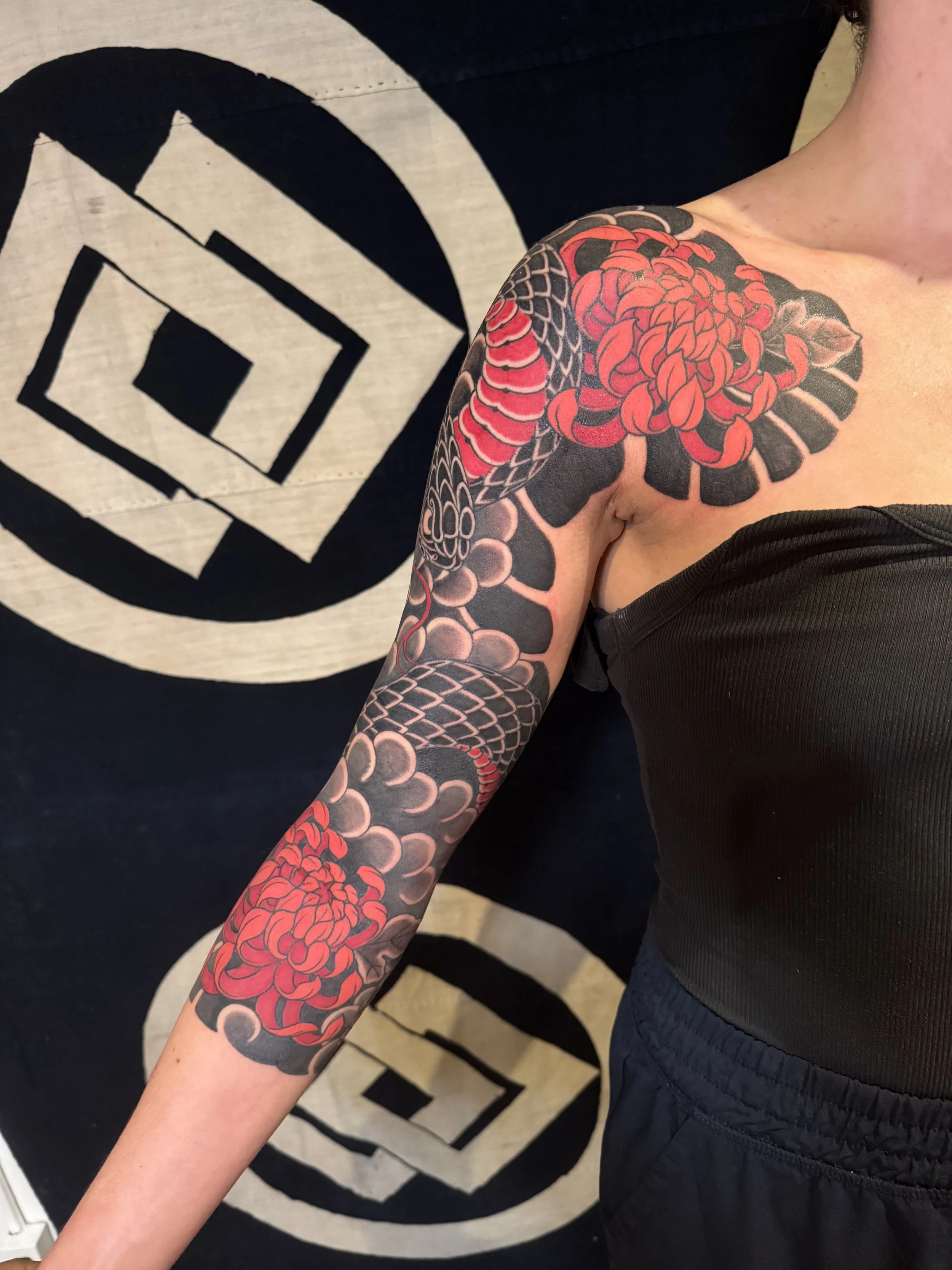 Bold colorful 3/4 Japanese sleeve with chest plate on woman with snake, wind bars and mums