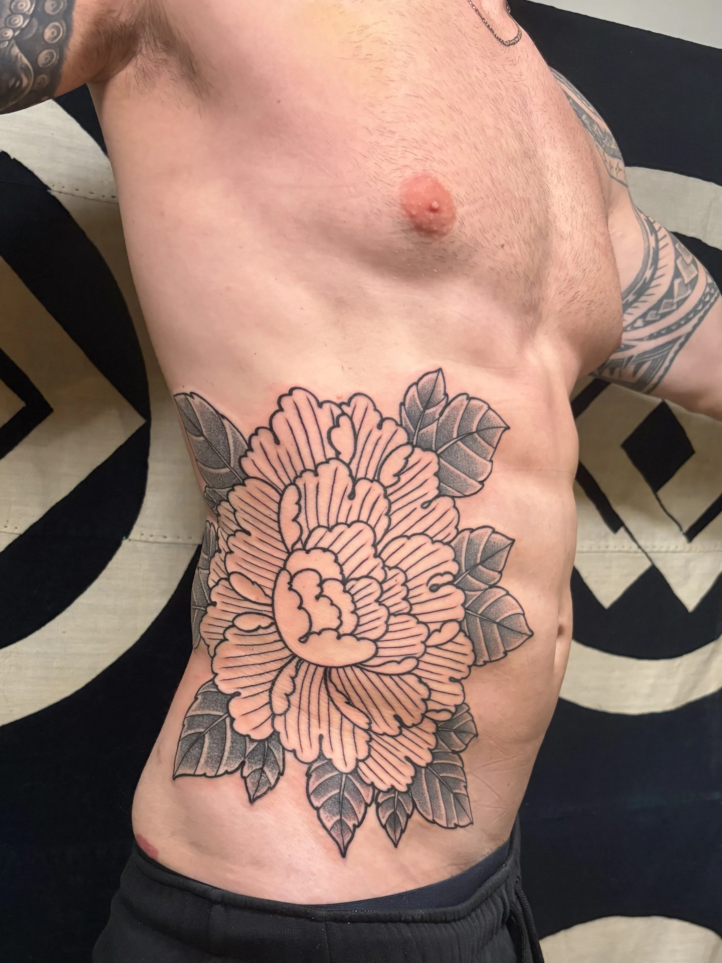 Men's Japanese Peony large scale blackwork tattoo on side / rib