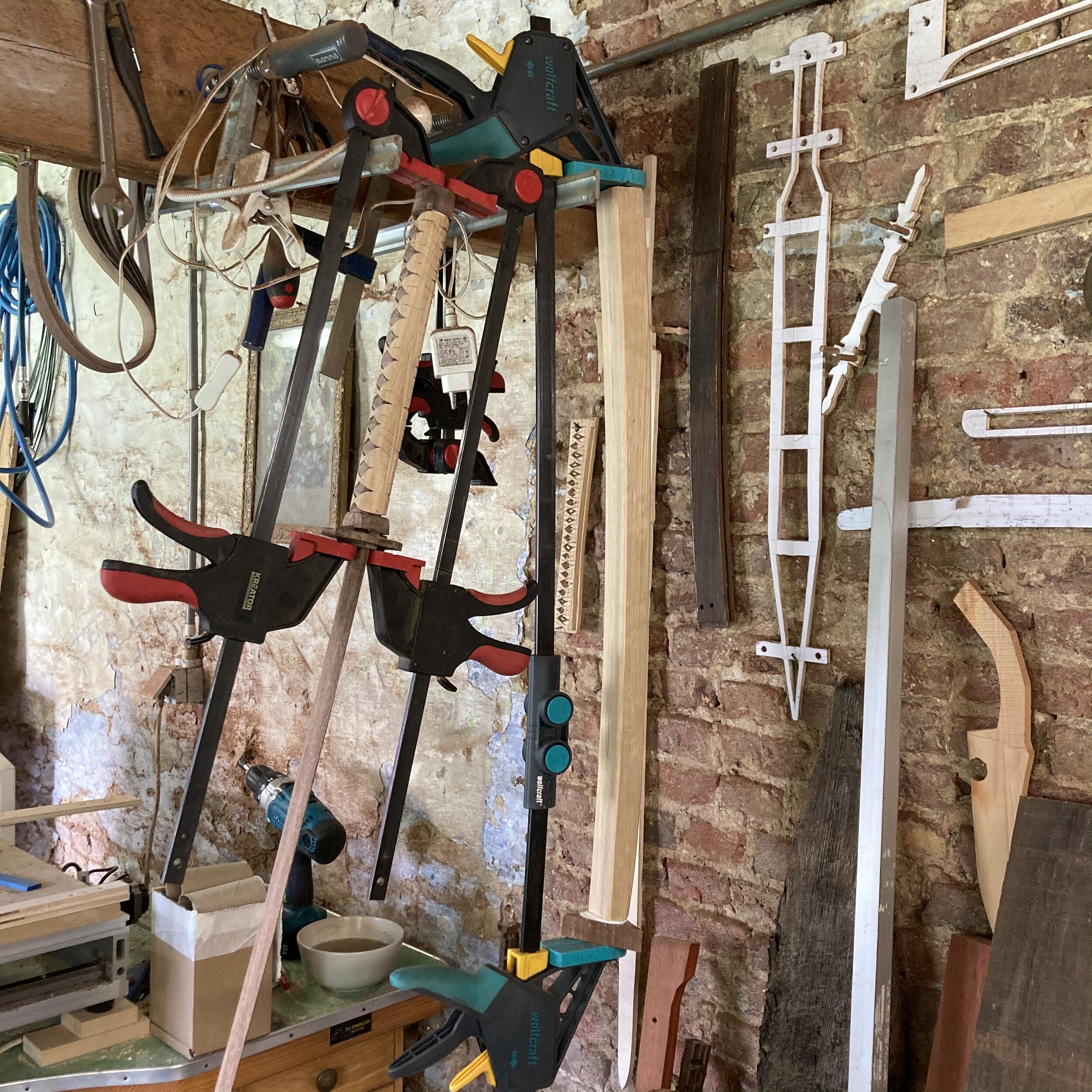 Almost done. Fitting the Tsuba and the rough shape of the Saya. And some lovely testpieces and designs from previous creations on the wall.