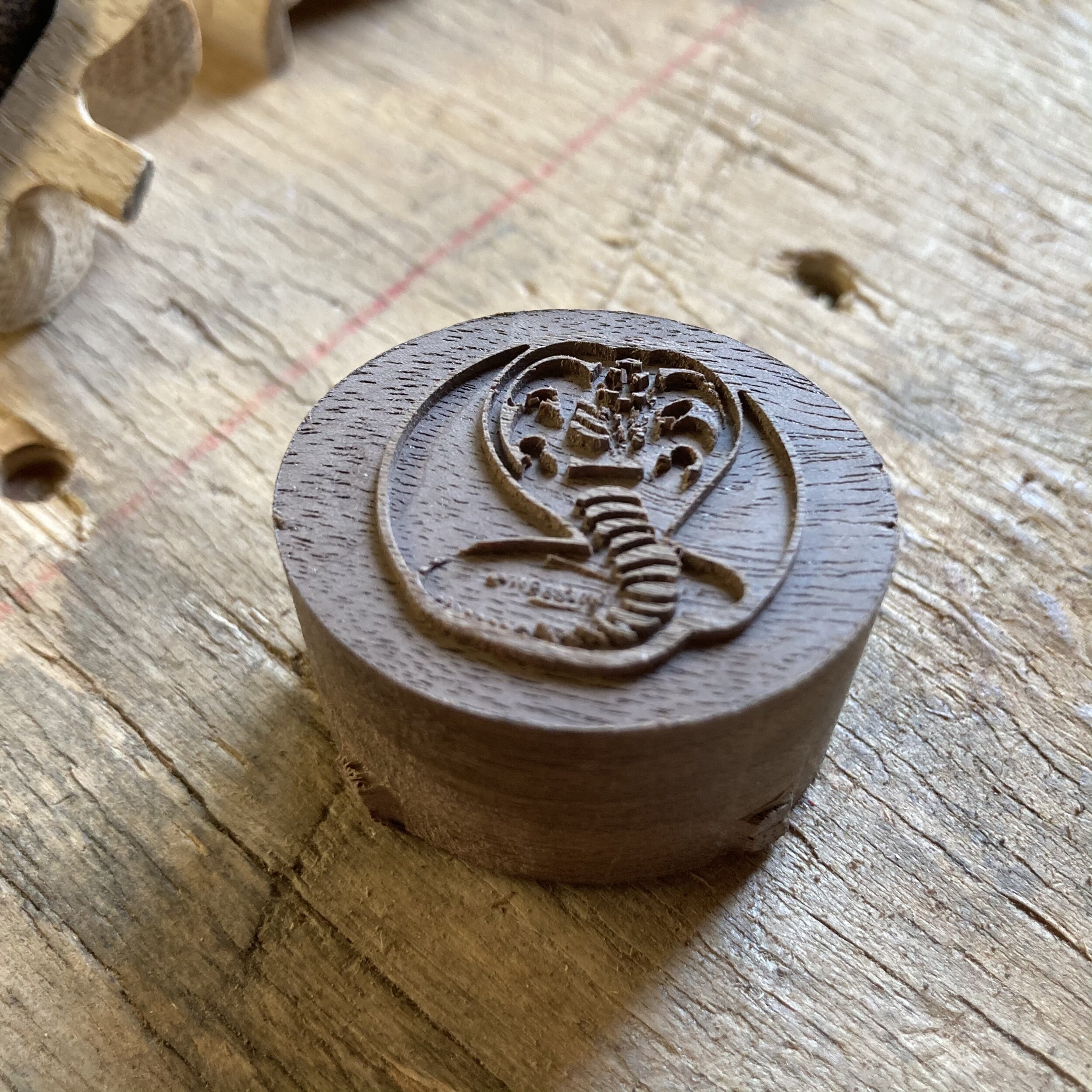 The Cobra-Kai logo, engraved in the kashira. Also walnut.