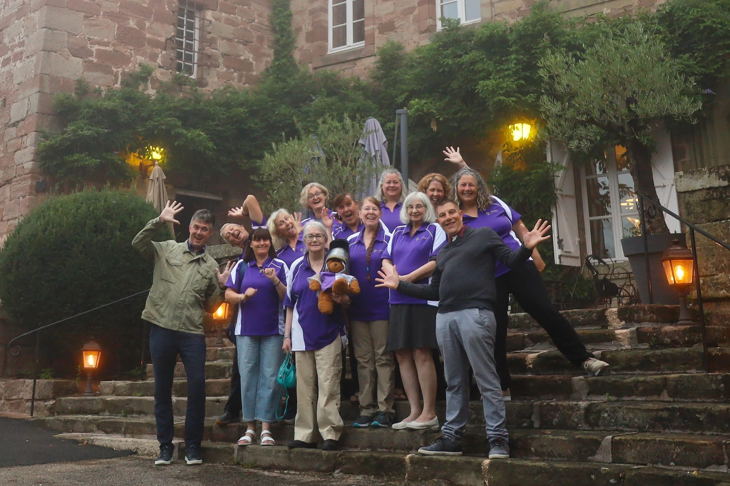 Plantagenet Discoveries guests and tour team laughing together in their purple shirts during a historical tour in France.