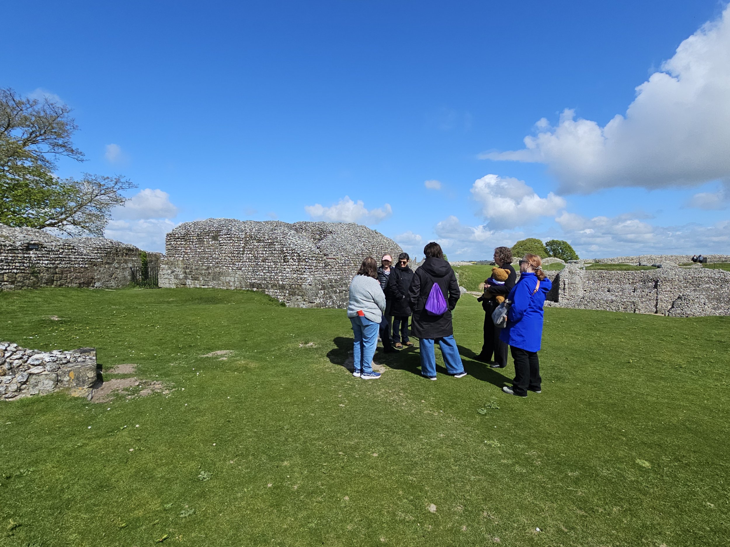 Plantagenet Discoveries guests gathered together among the medieval ruins of Old Sarum near Salisbury, England, beneath a bright blue sky.