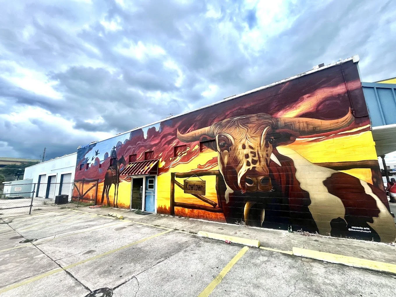 An image of the pilgrims landing mural on Broadway Kissimmee Florida. Depicts a cowboy and cow.