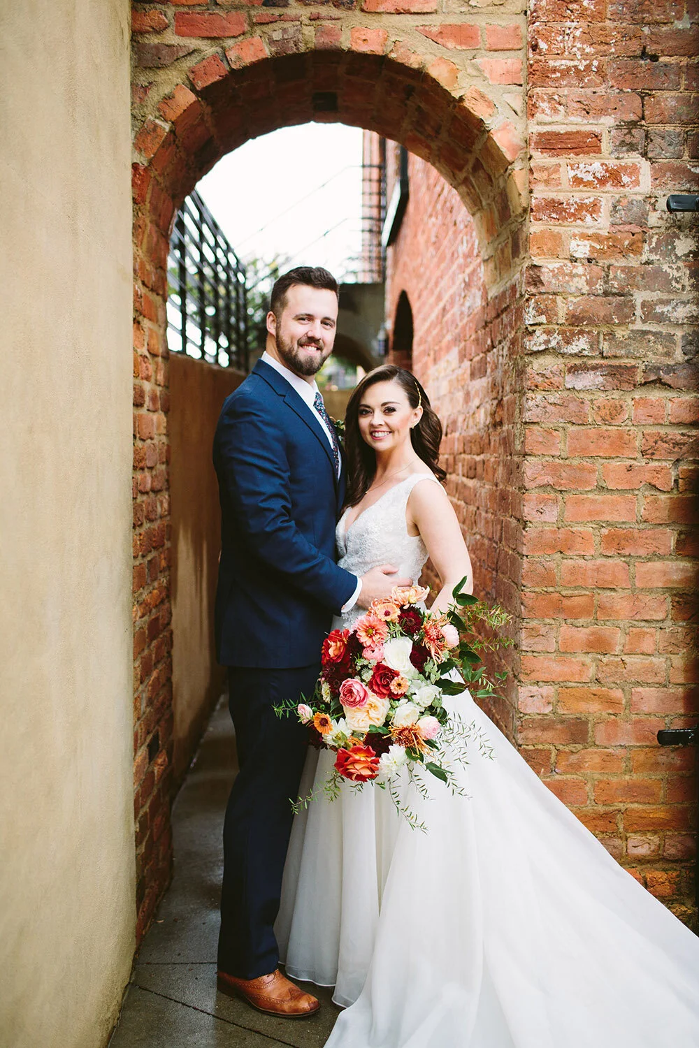Penny_Bride_Groom_Smiling_At_Camera_With_Bridal_Bouquet.jpg