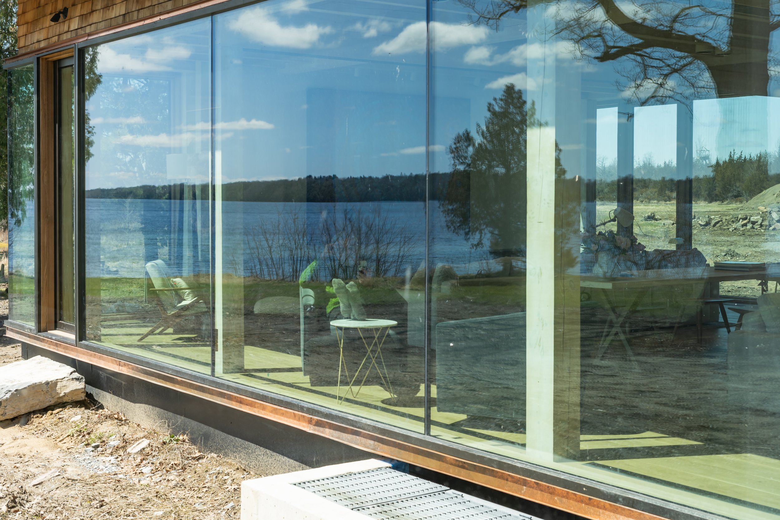 Reflection of lake and trees on glass windows of a modern building