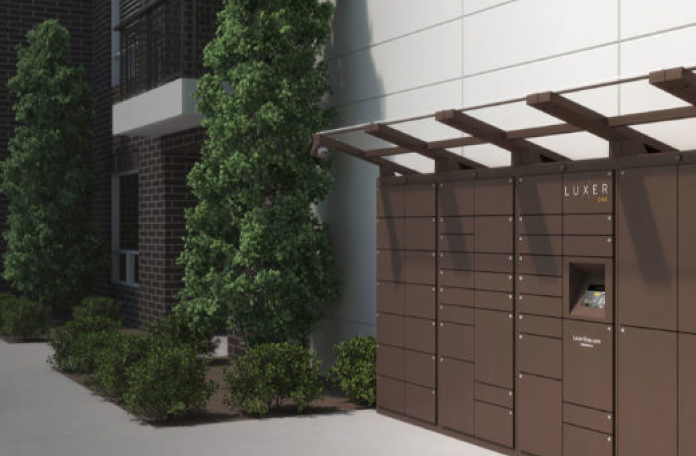 Brown Luxer One outdoor package lockers under a pergola beside an apartment building