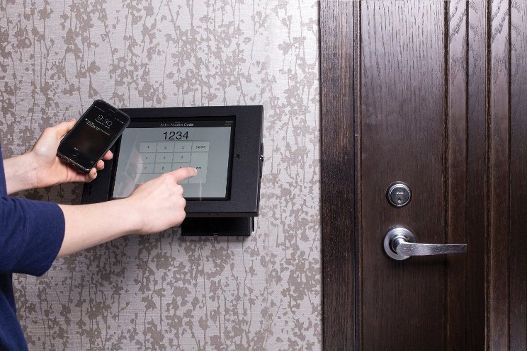 A resident entering an access code on the package room keypad beside the door
