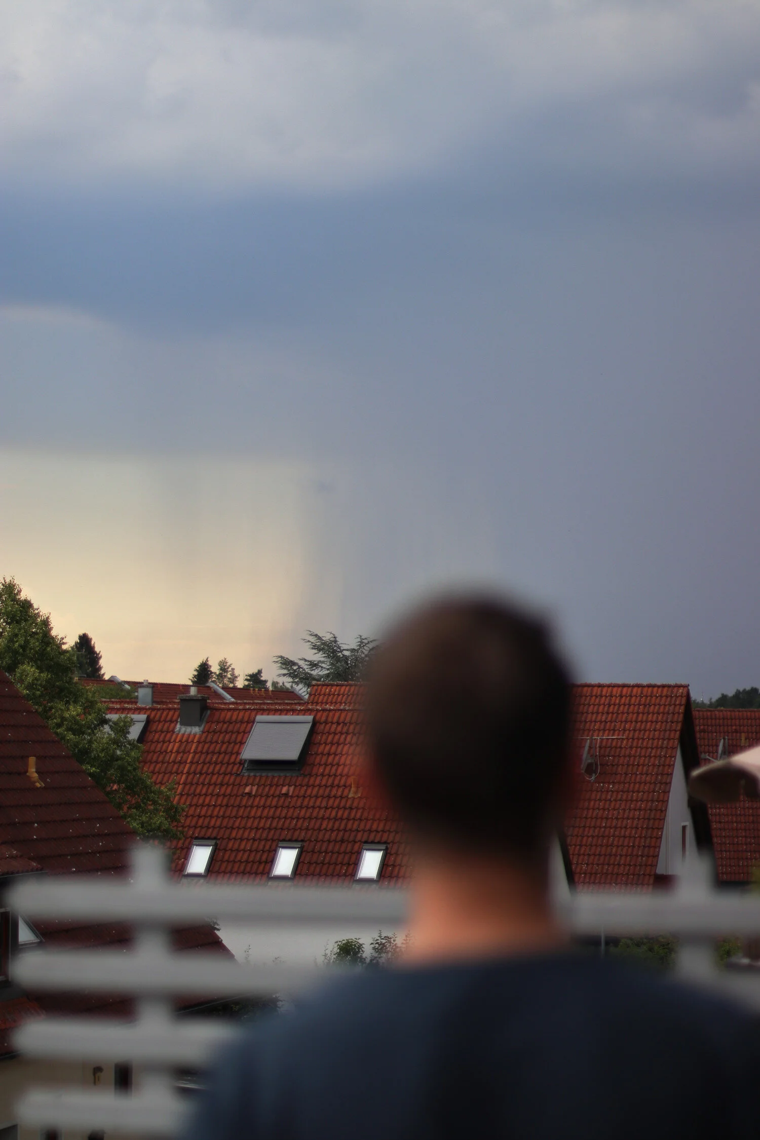 Dieses Foto zeigt Philipp mit Ausblick auf den Regen über den Dächern.