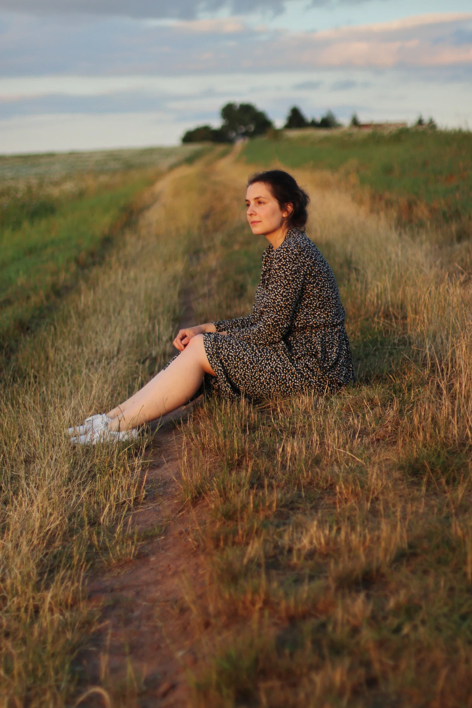 Dieses Bild zeigt Luisa am Feld sitzend im Sonnenschein.
