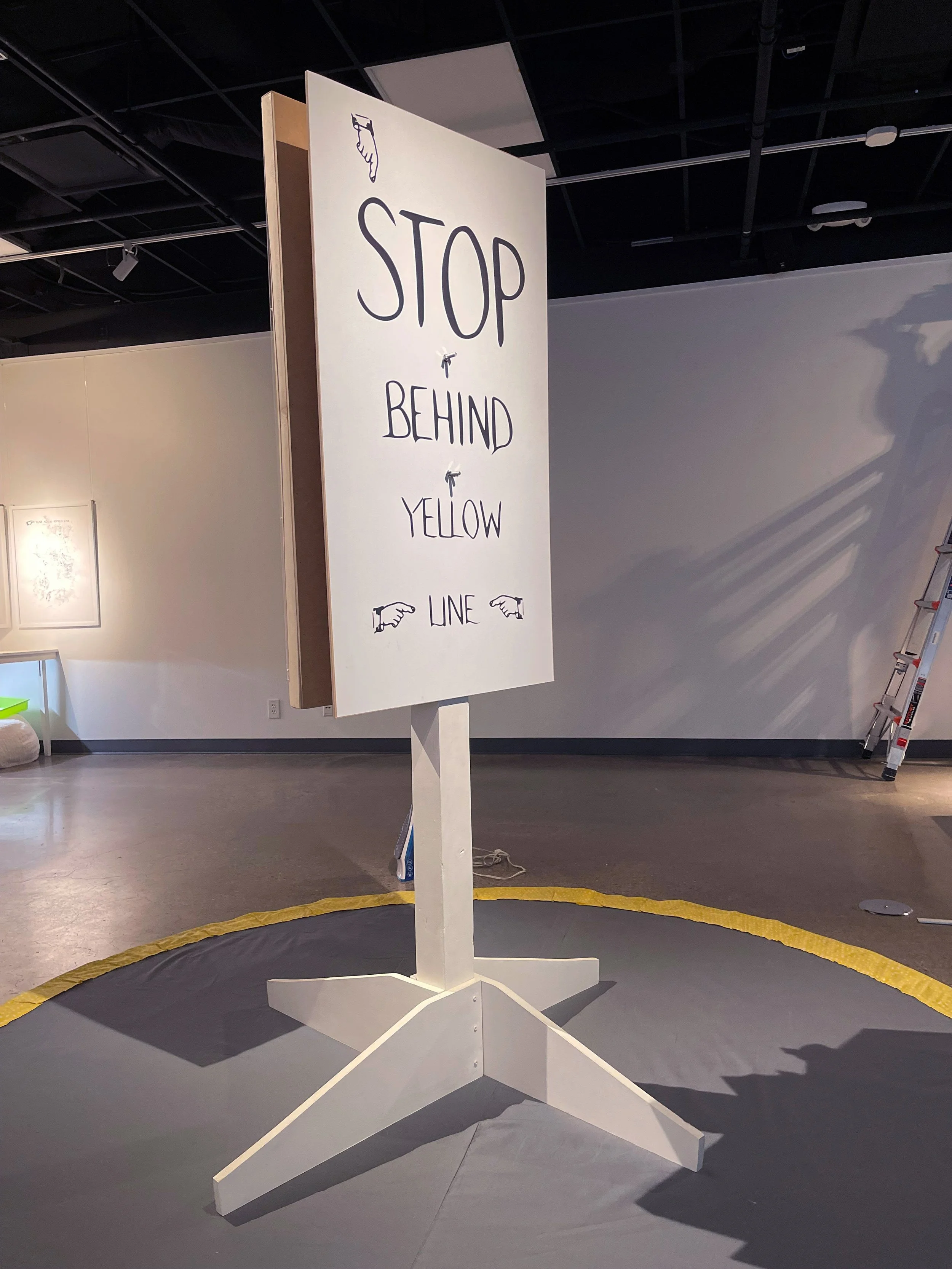 STOP BEHIND YELLOW LINE, 2023-24, Front, Media: Laser print on fabric, wood, bolts and miscellaneous hardware, gumballs, textiles, Poetry. Factory members: Esi Boulet, Theresa Devine
