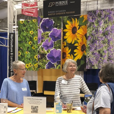 Linda (center) volunteered, along with Deb Allmayer (left) at the Purdue Extension Master Gardener Booth at the Indiana State Fair in 2022.
