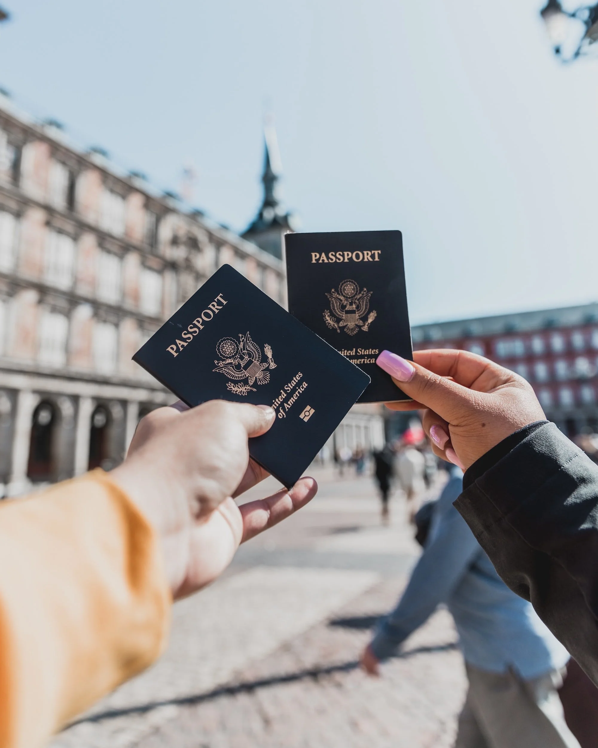 Two travelers holding United States passports outdoors